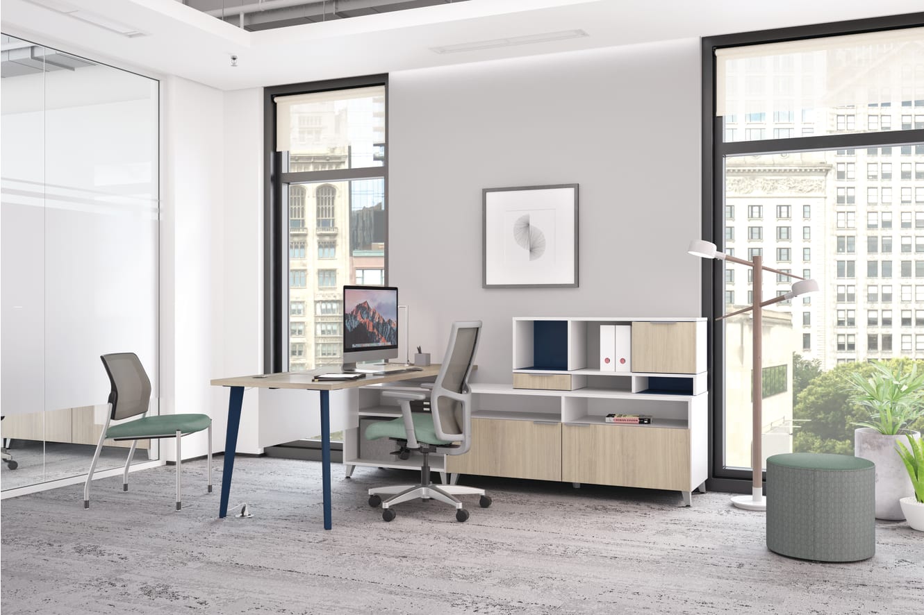 A modern and minimalist office space with a desk, chairs, and storage units, set against a backdrop of large windows overlooking a cityscape.