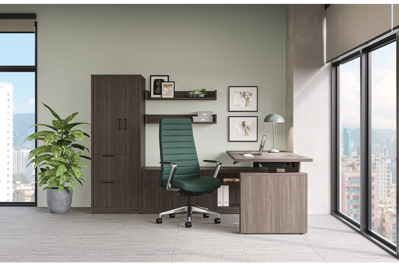 Modern private office with wood desk and storage cabinets, green task chair, framed wall art, and floor-to-ceiling windows with city views.