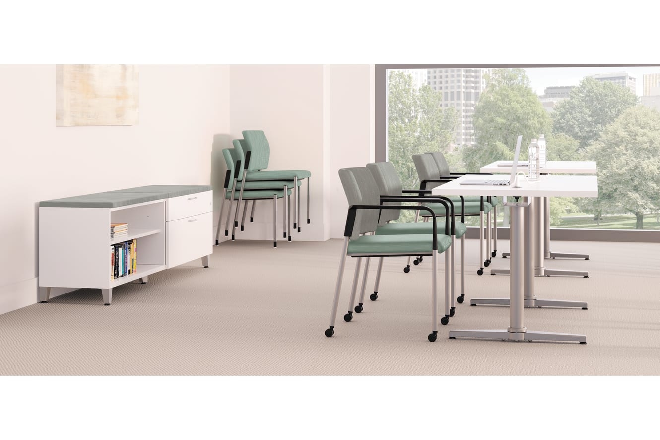 A modern, minimalist office space with a storage unit, rolling chairs, and a view of the outdoors through a large window.