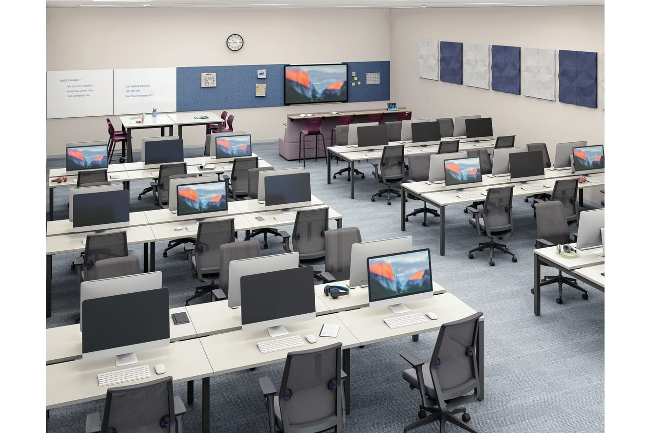 Modern computer lab with rows of desktop workstations, ergonomic task chairs, collaborative instructor station, interactive display, whiteboards, and technology-enabled learning space in a contemporary educational environment.
