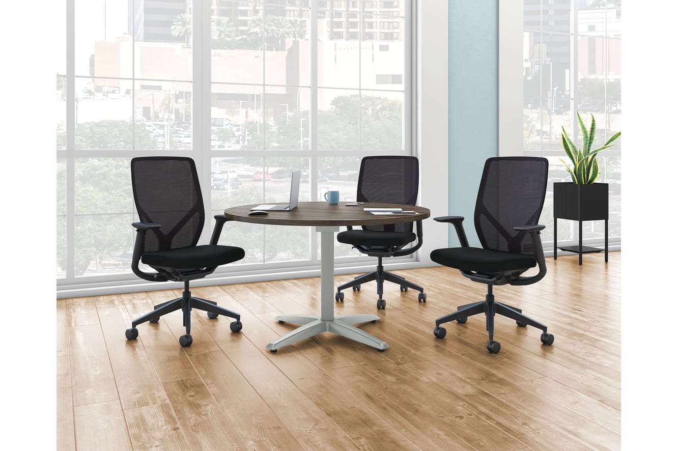 A Preside round conference table with three Flexion task chairs.