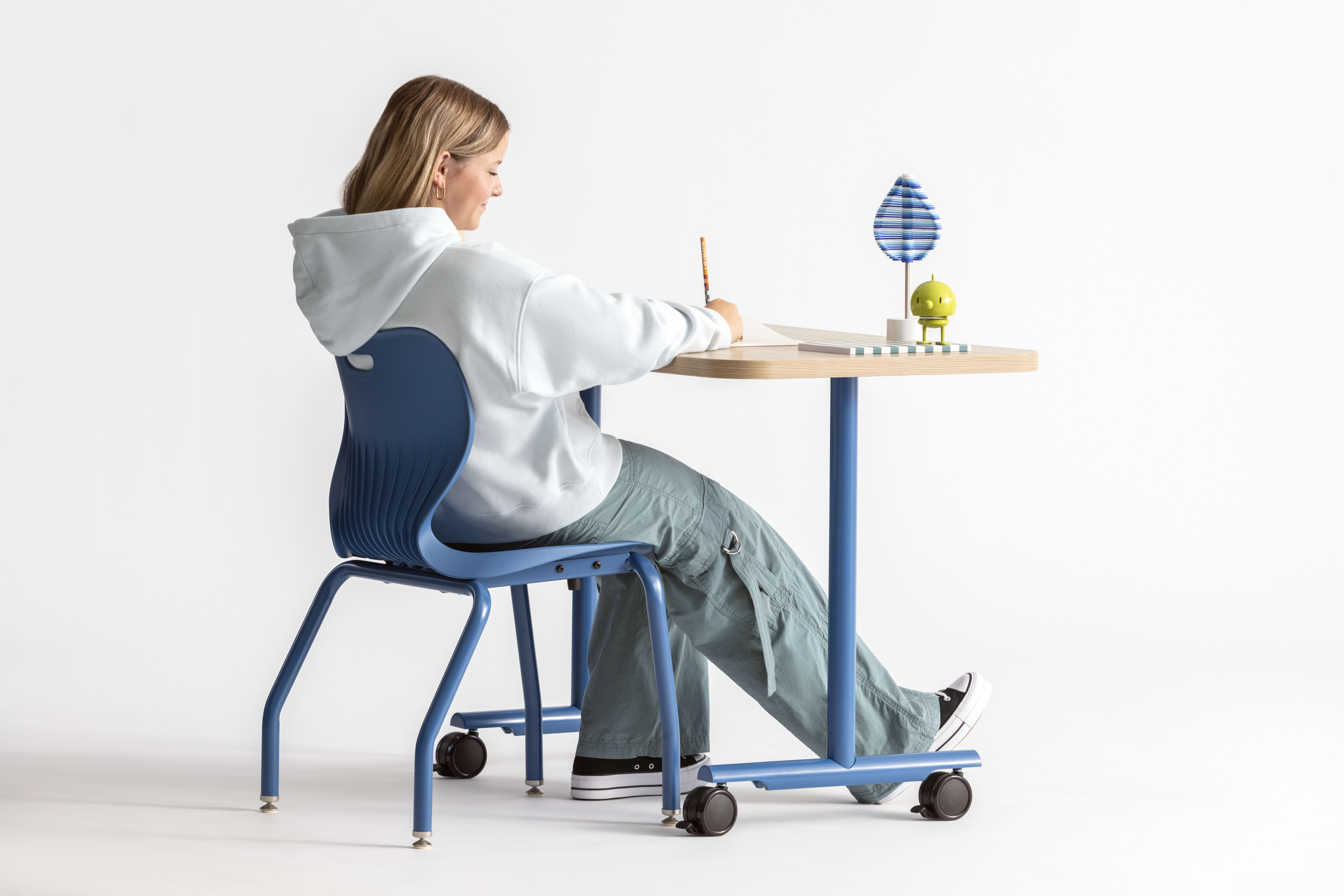 One student seated in a blue monotone Smartlink chair at a Field Trip table with matching blue legs.