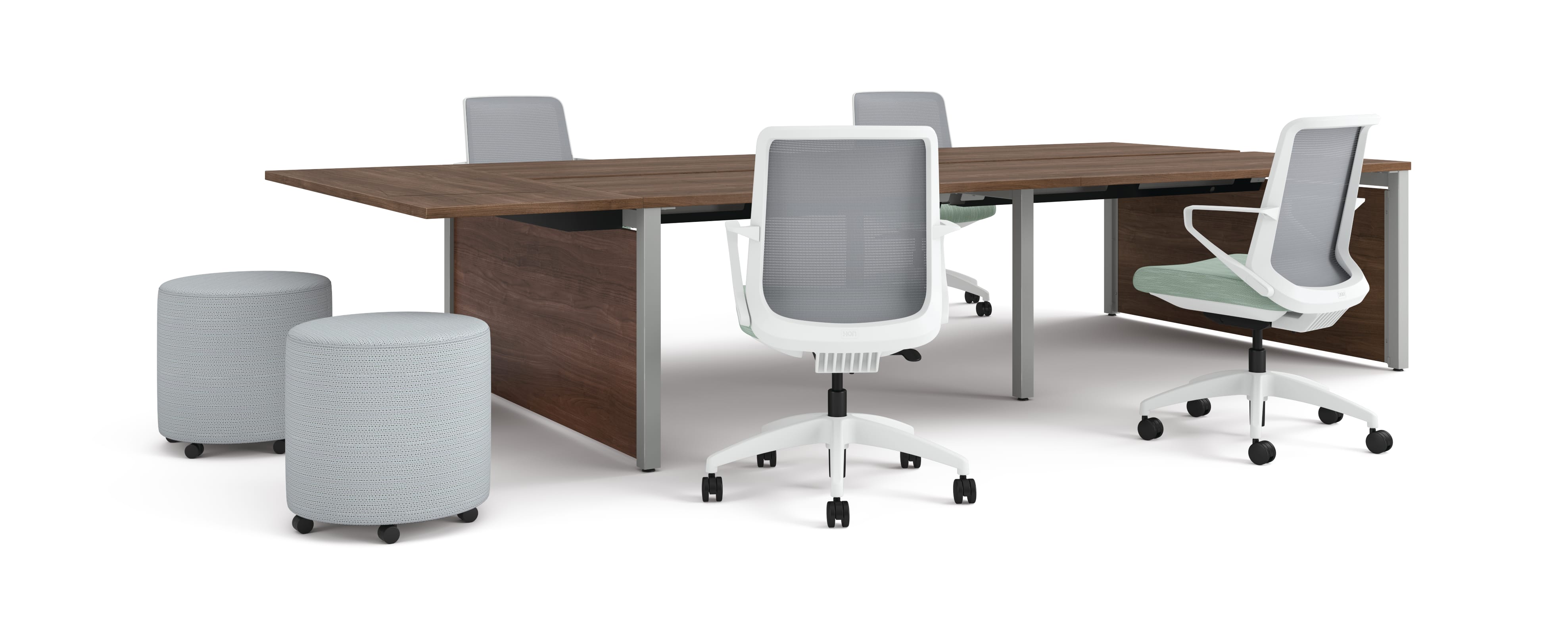 Four ergonomic office chairs around two connected rectangular desks with wooden tops, accompanied by two round upholstered stools.