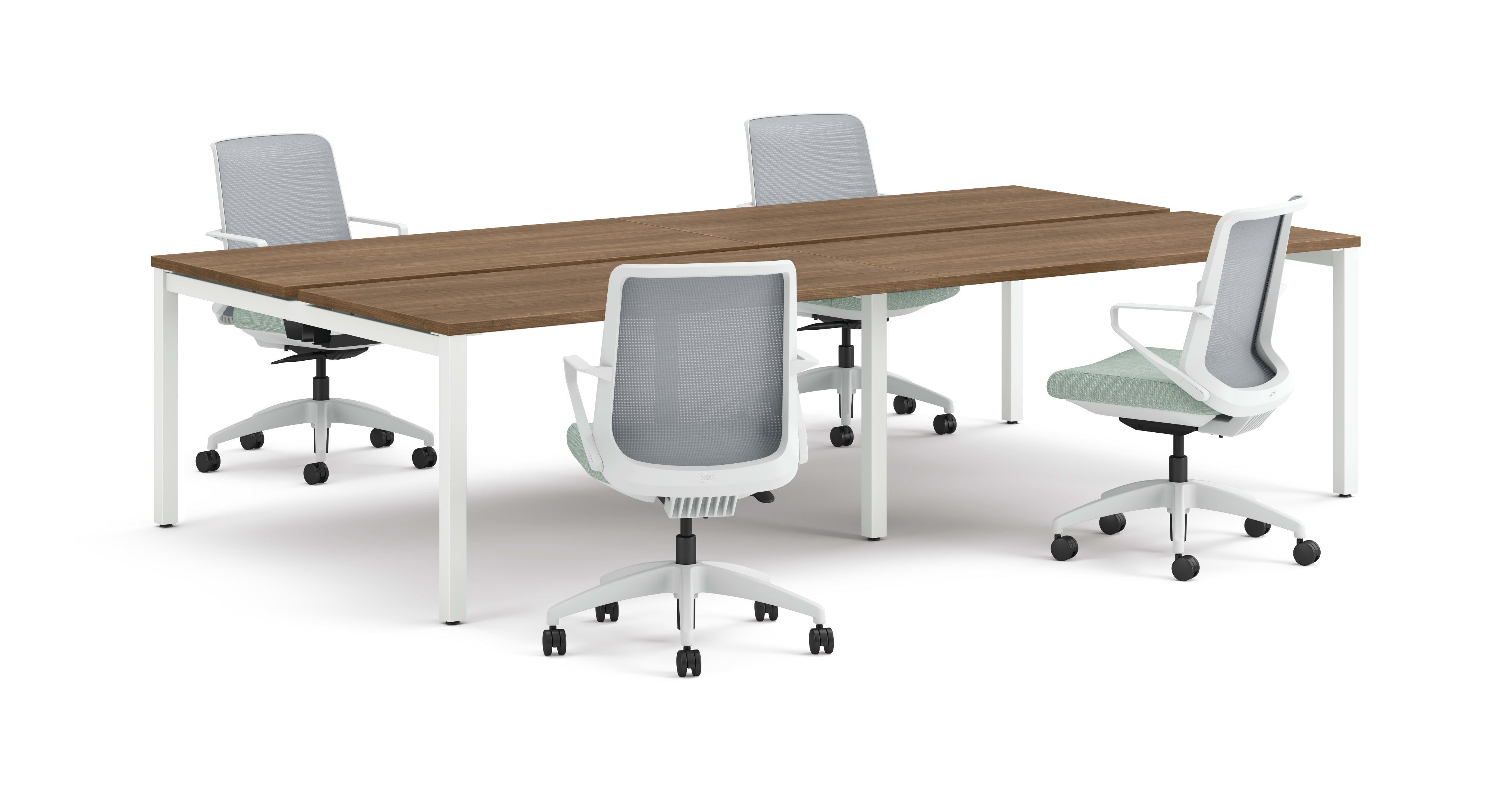 Four ergonomic office chairs arranged around two connected rectangular desks with wooden tops and white legs.
