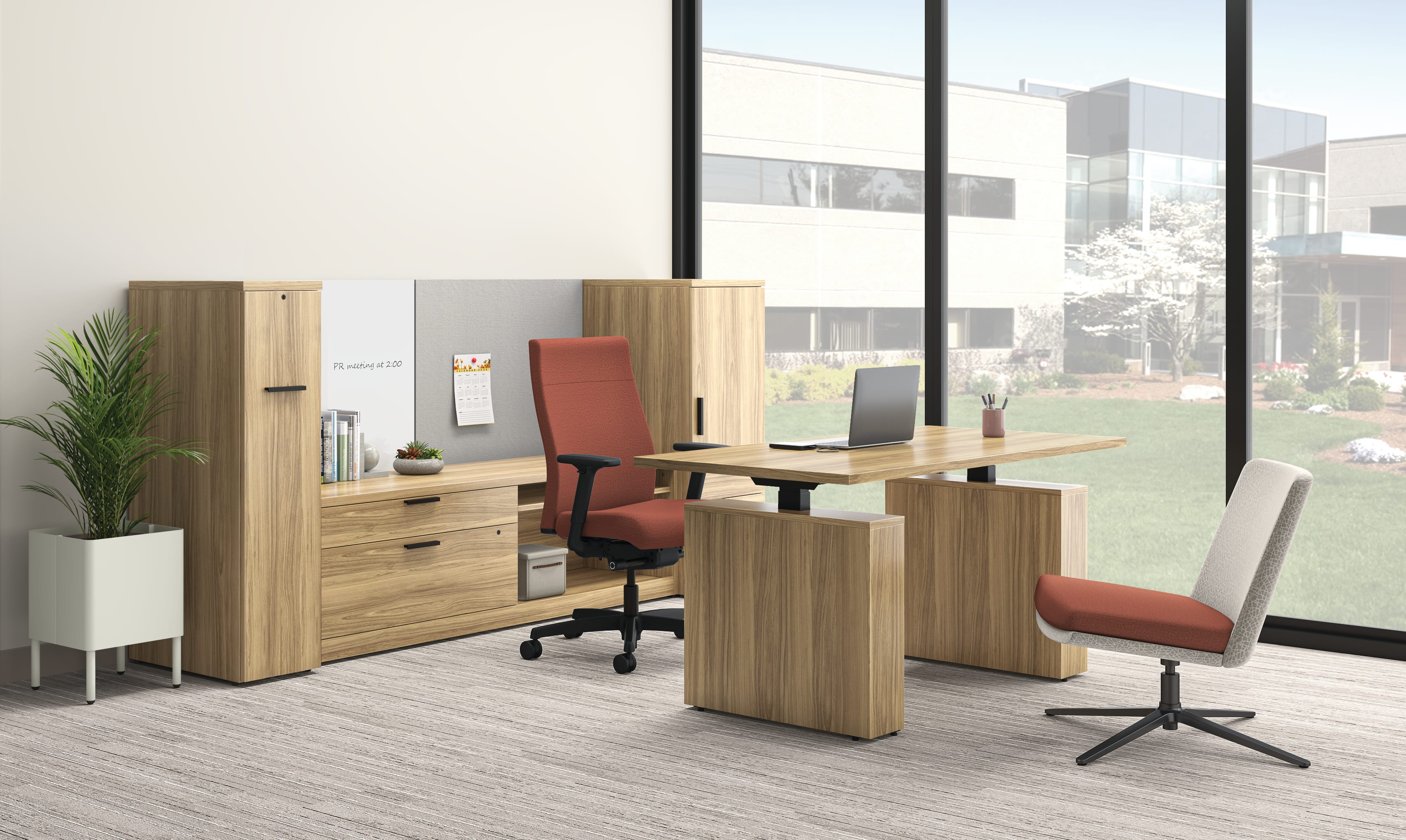 Contemporary office setup featuring wood-finish desk, ergonomic chair with rust-colored upholstery, side chair, storage cabinets, and large windows overlooking landscaped exterior.