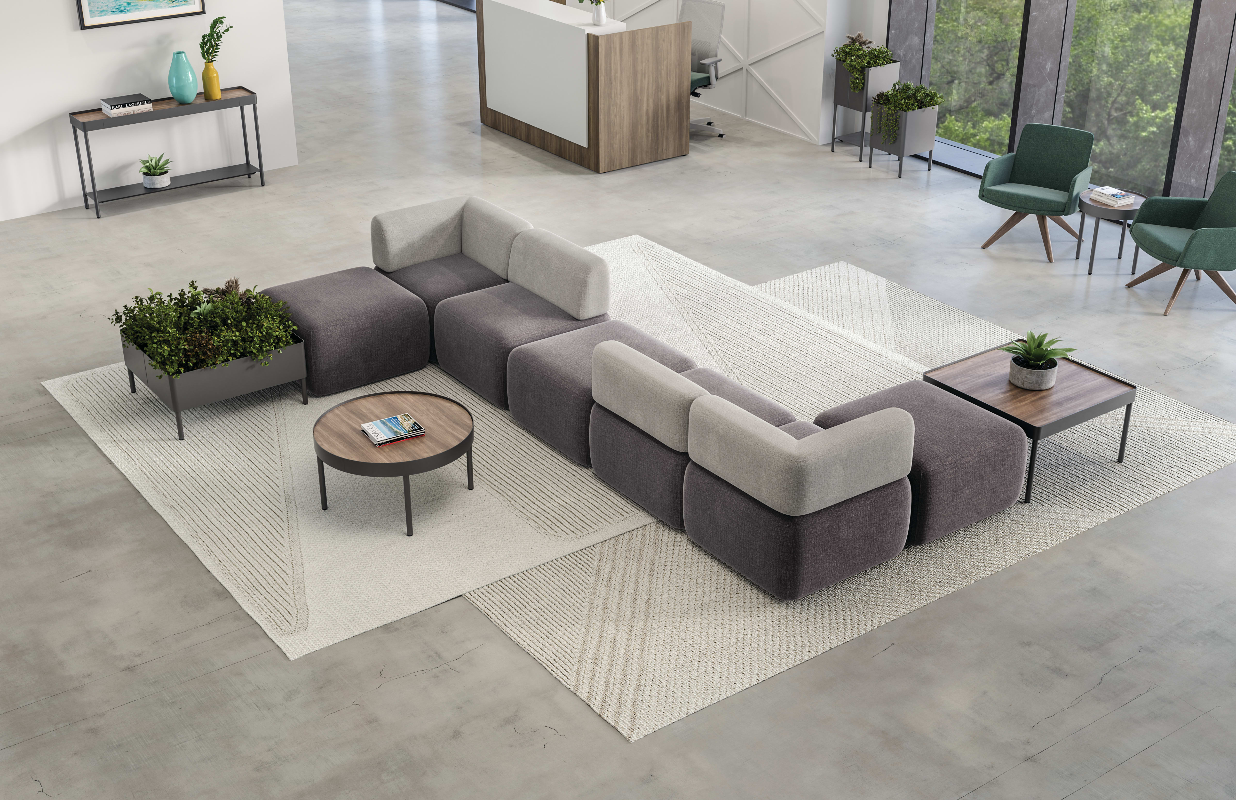 SoCo multi-fabric modular lounge in reception area with Sculpt occasional tables & planters near 10500 Series station and Mav seating.