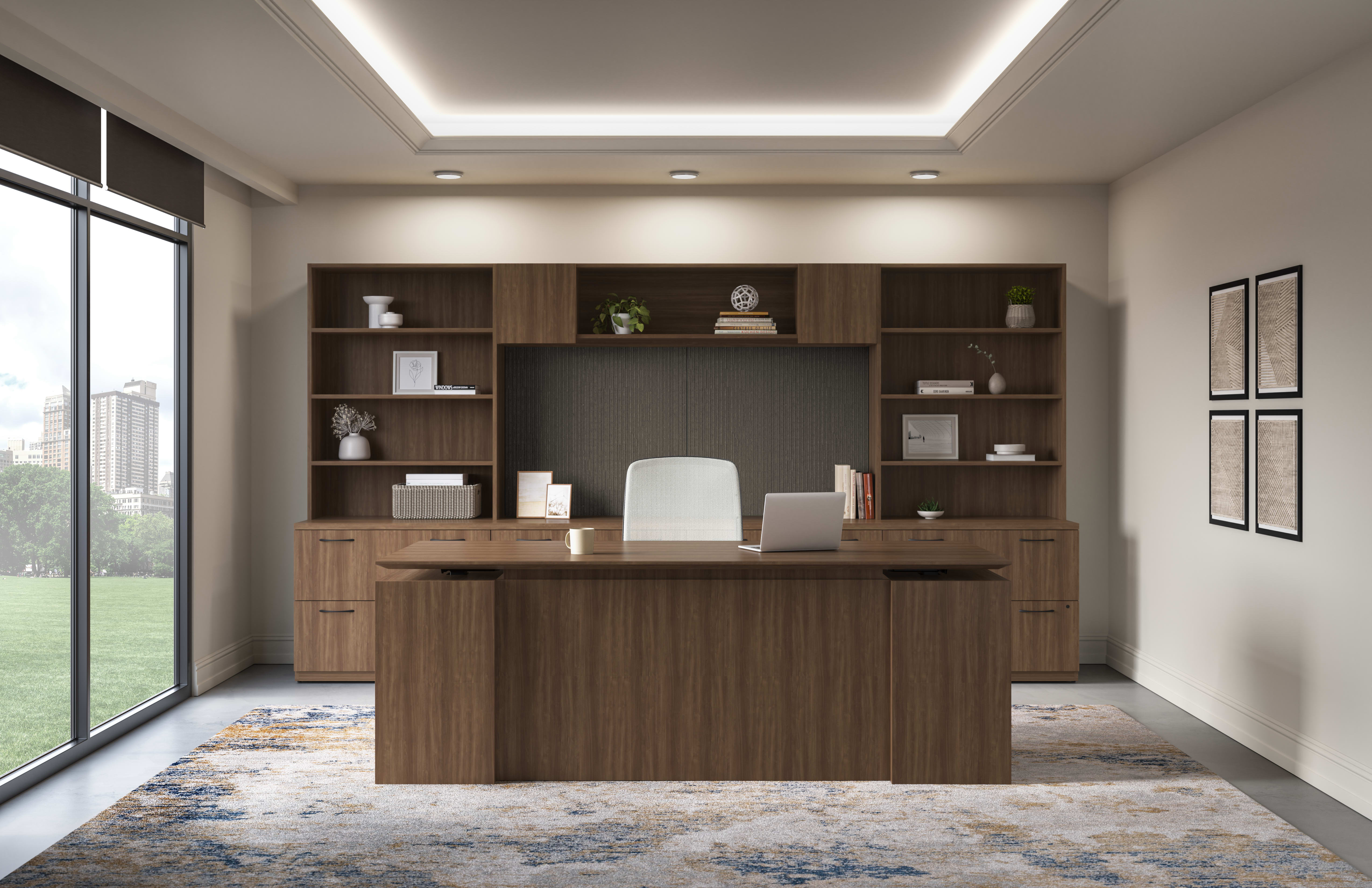 Concinnity Height-Adjustable Single Desk in dark laminate and Nucleus Task Chair in light fabric, centered in a private office with a wall of storage and display shelves behind them.