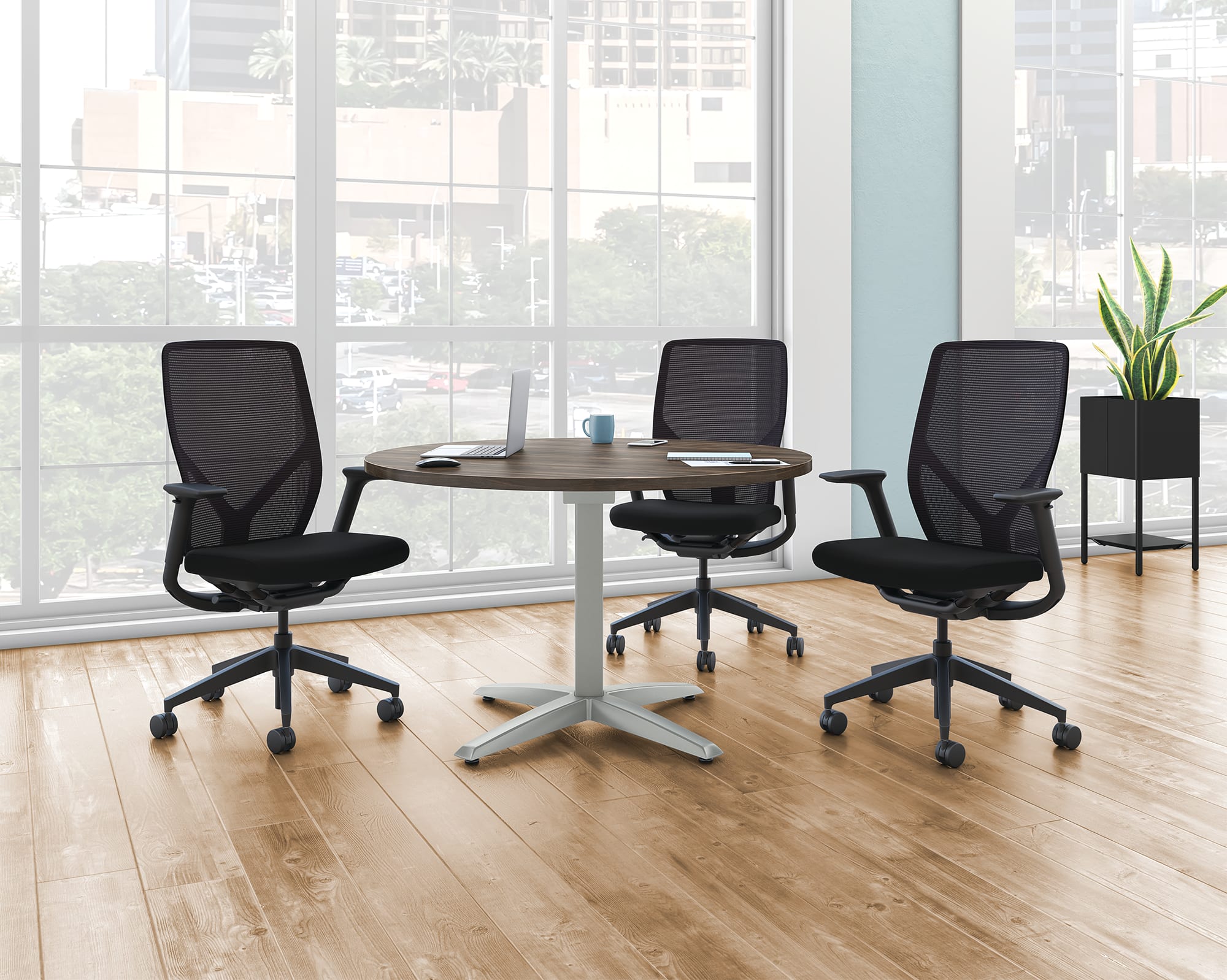 A Preside round conference table with three Flexion task chairs.