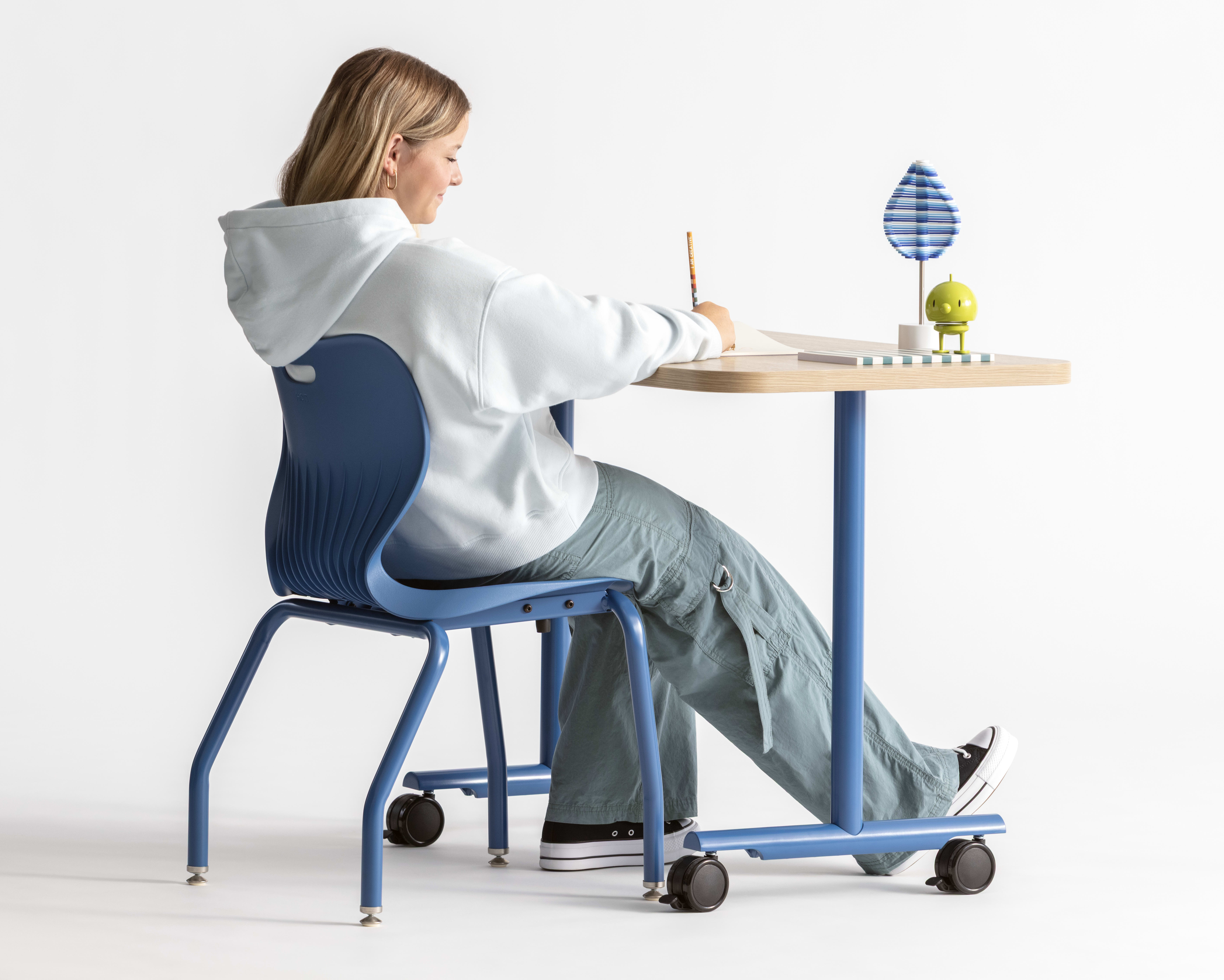 One student seated in a blue monotone Smartlink chair at a Field Trip table with matching blue legs.