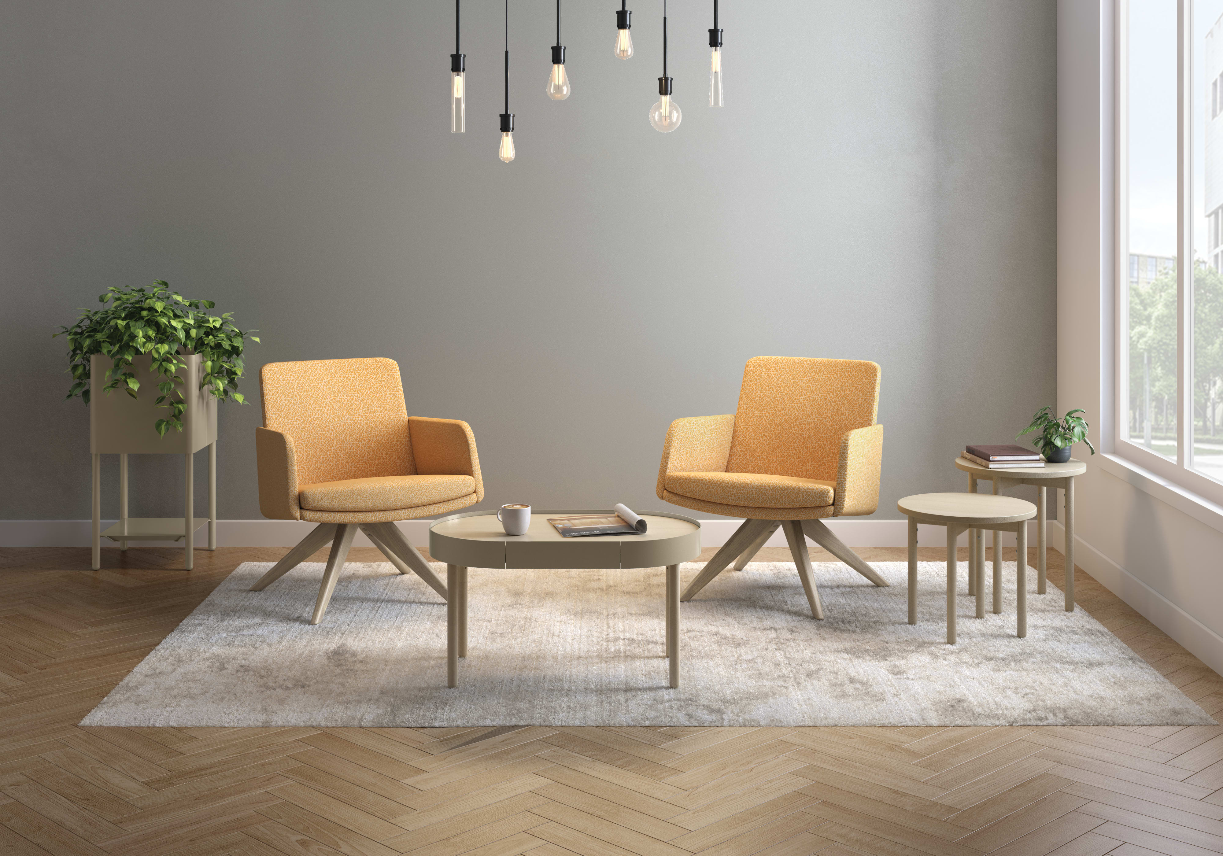Contemporary office lounge featuring beige sofa, two navy chairs, white tables, and hexagonal wall panels.