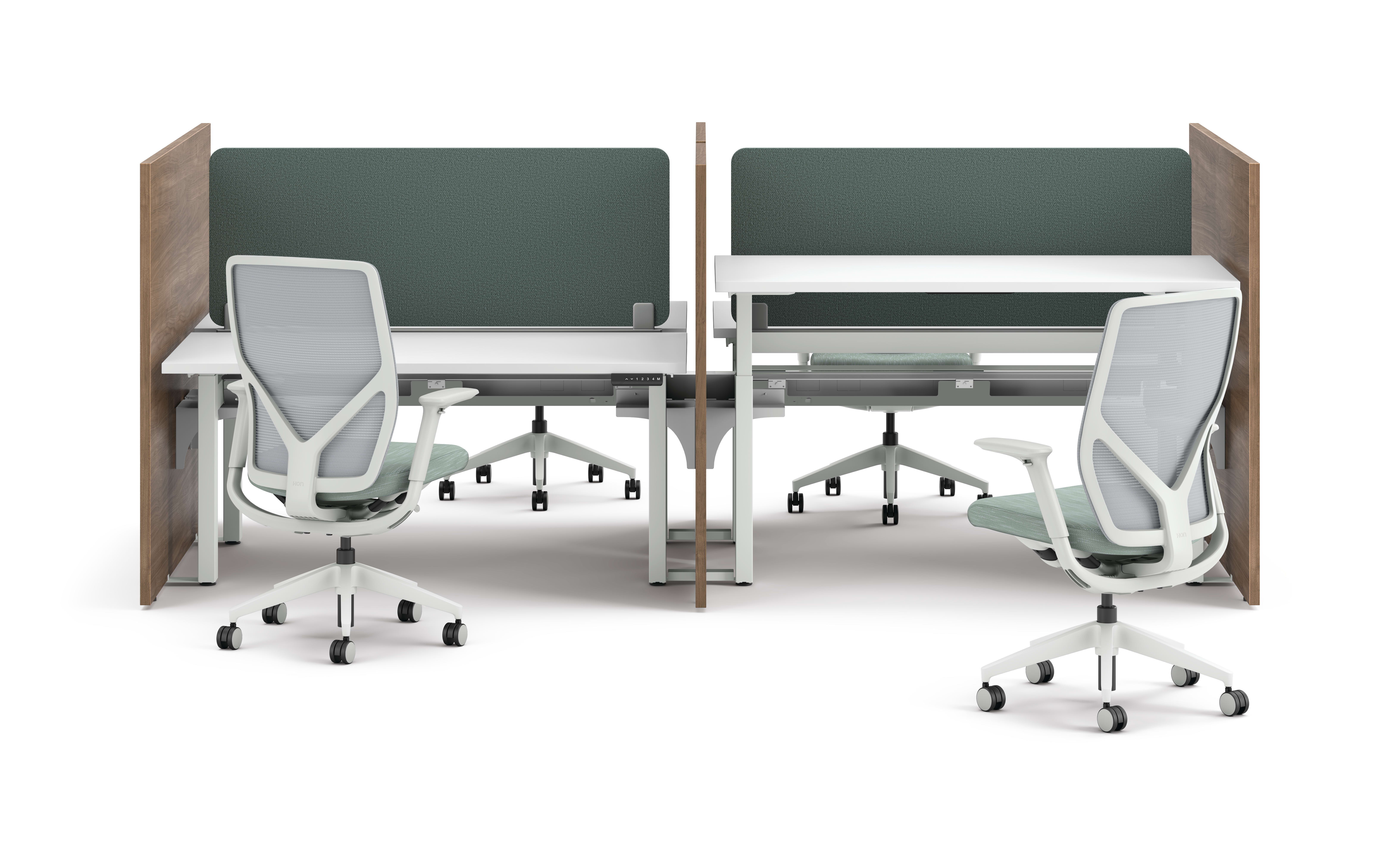 Two workstations with green fabric privacy panels, white desks, and ergonomic office chairs framed by wooden side panels.