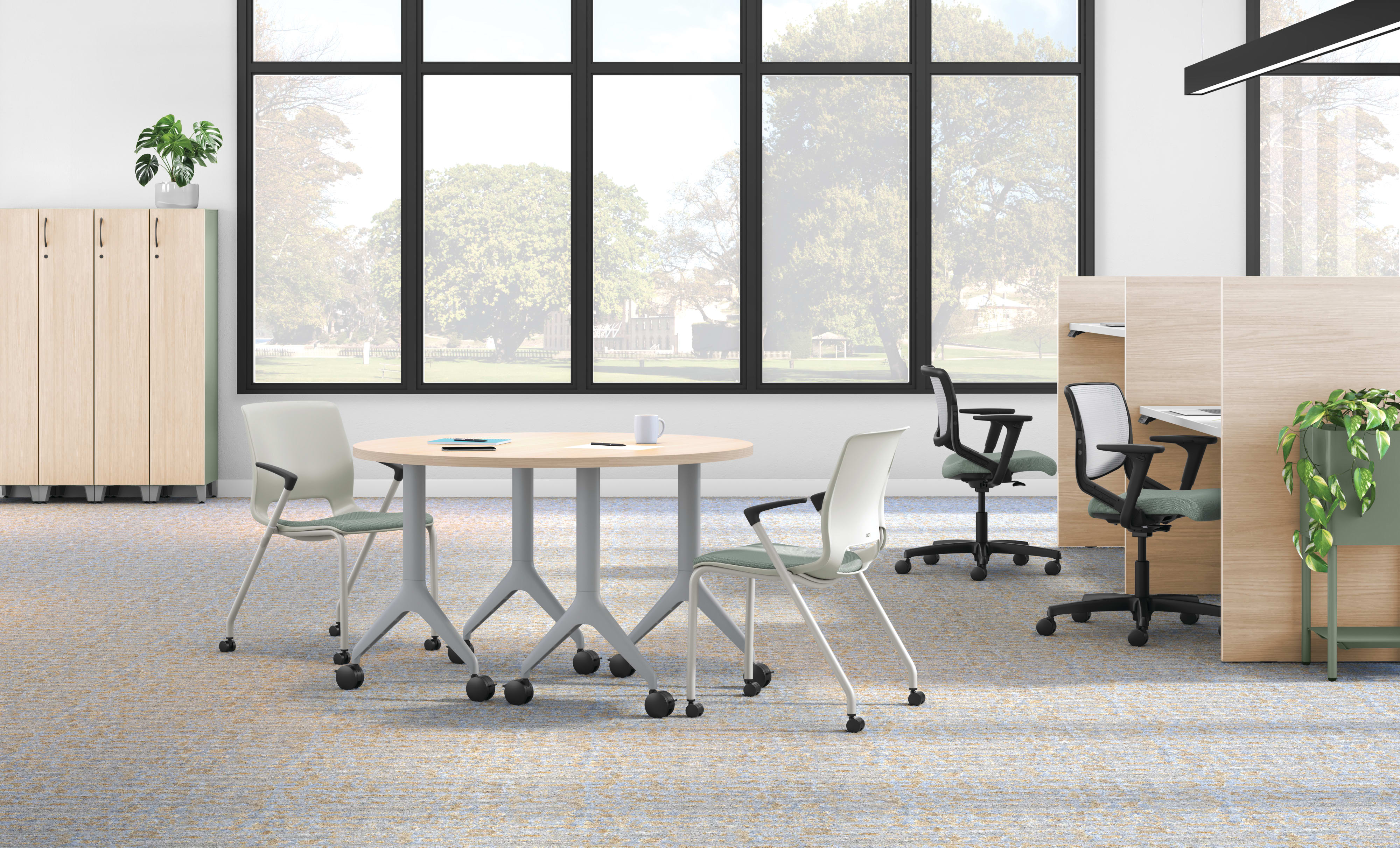 Open workstation view of Motivate 4-leg stacking and flex-back chair with Contain wardrobe locker and Motivate half-round table