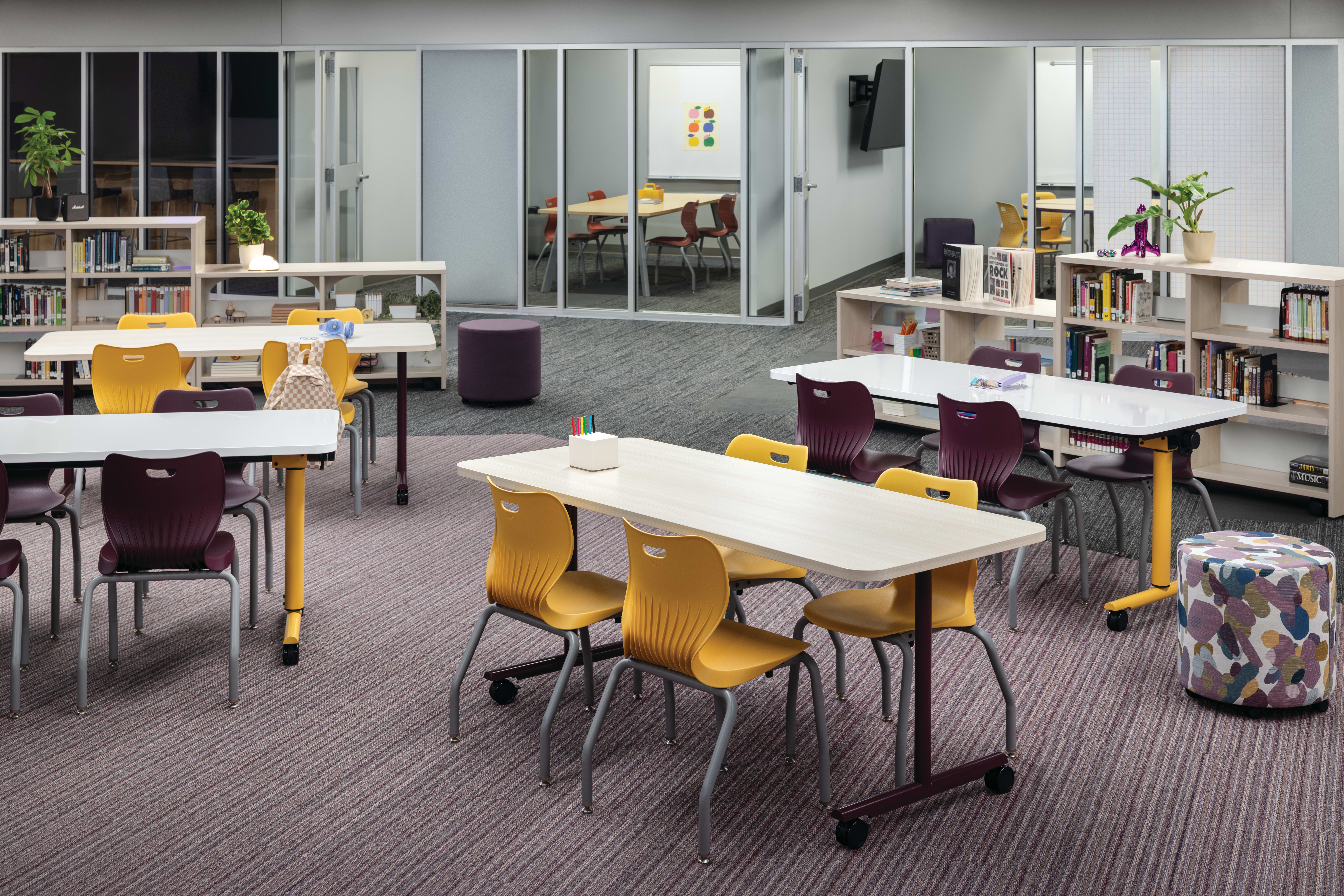 Field Trip tables with purple and yellow Smartlink chairs in a Multi-media Center with Storyline bookcases.