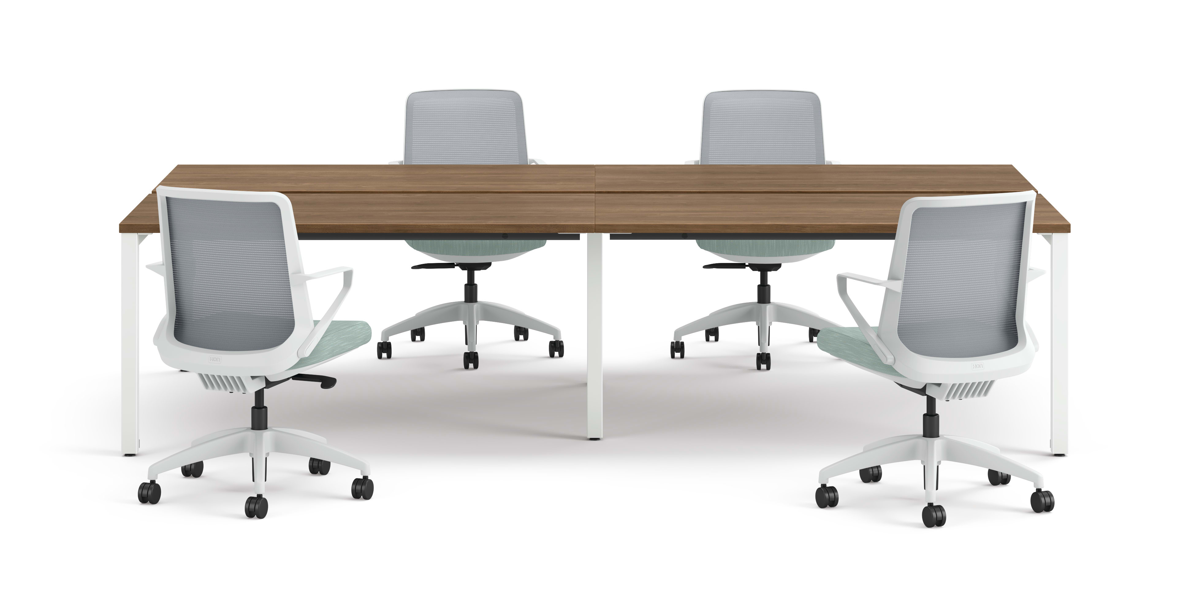Four ergonomic office chairs arranged around two connected rectangular desks with wooden tops and white legs.