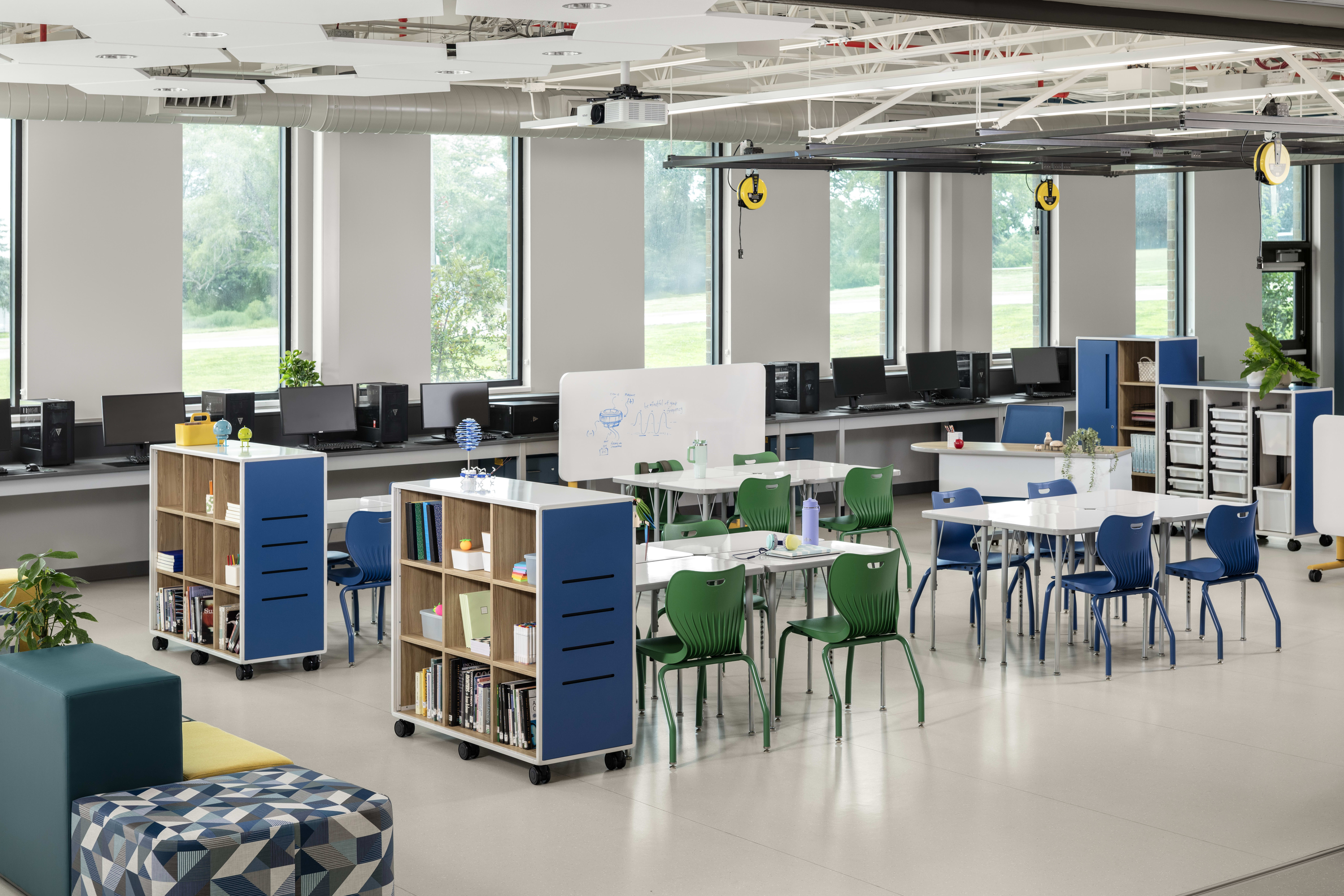 Makerspace classroom with blue and green chairs and storage solutions.