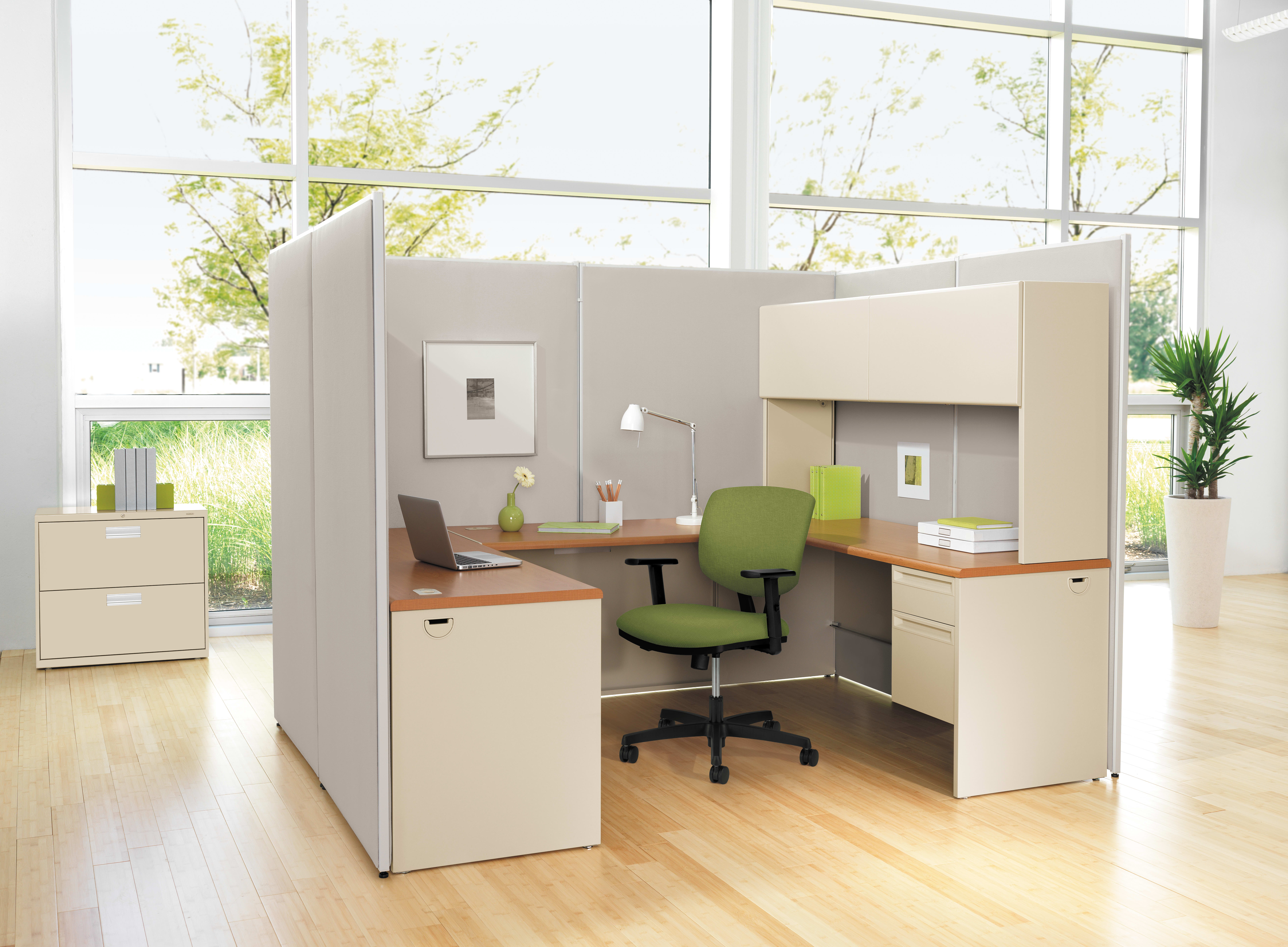 A modern, minimalist office space with cubicles, desks, and chairs arranged in a clean, organized manner, surrounded by large windows that allow natural light to flood the room.