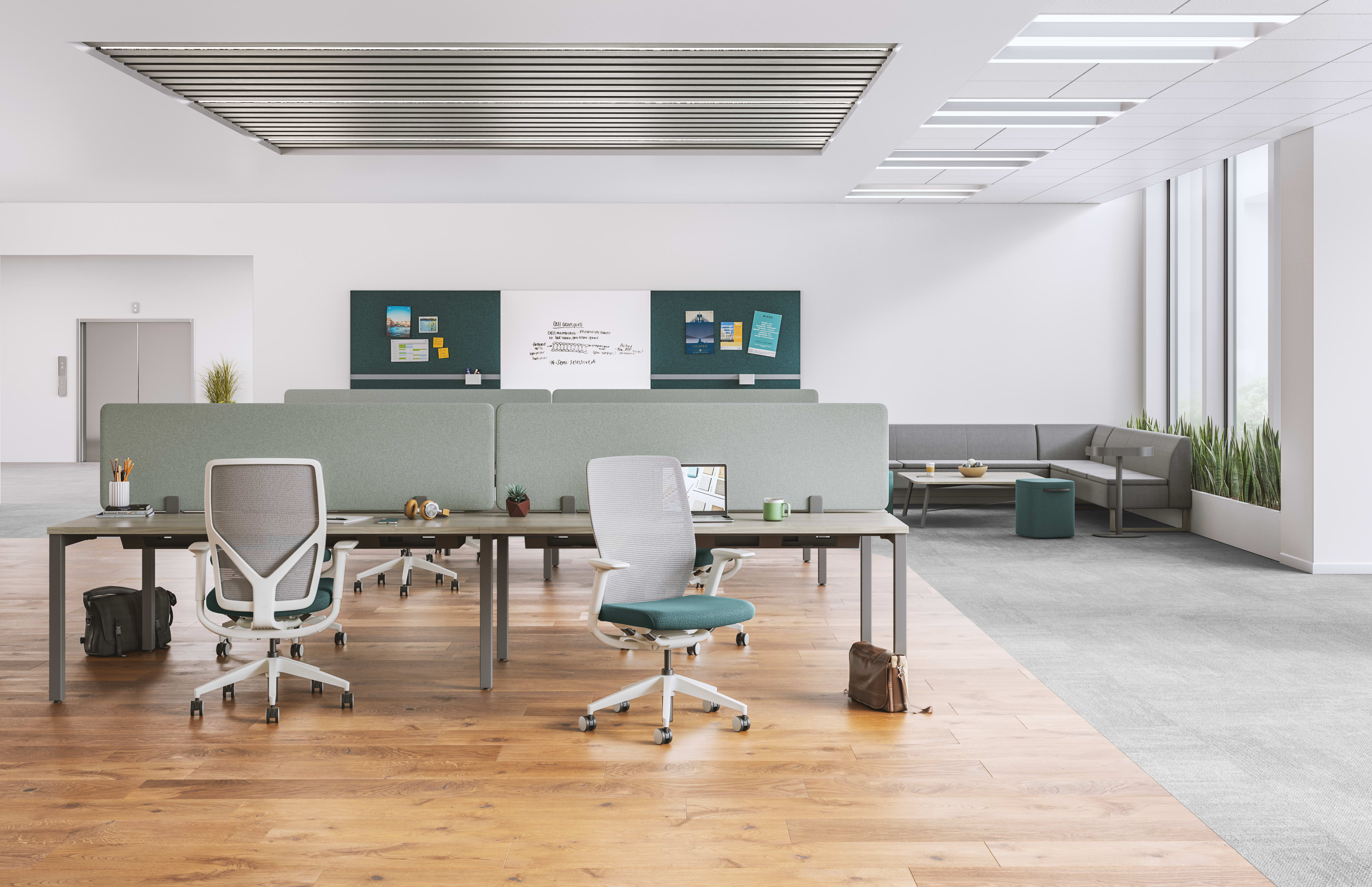 A modern, minimalist office space with a mix of gray and white furniture, including desks, chairs, and storage units, set against a bright, open background.