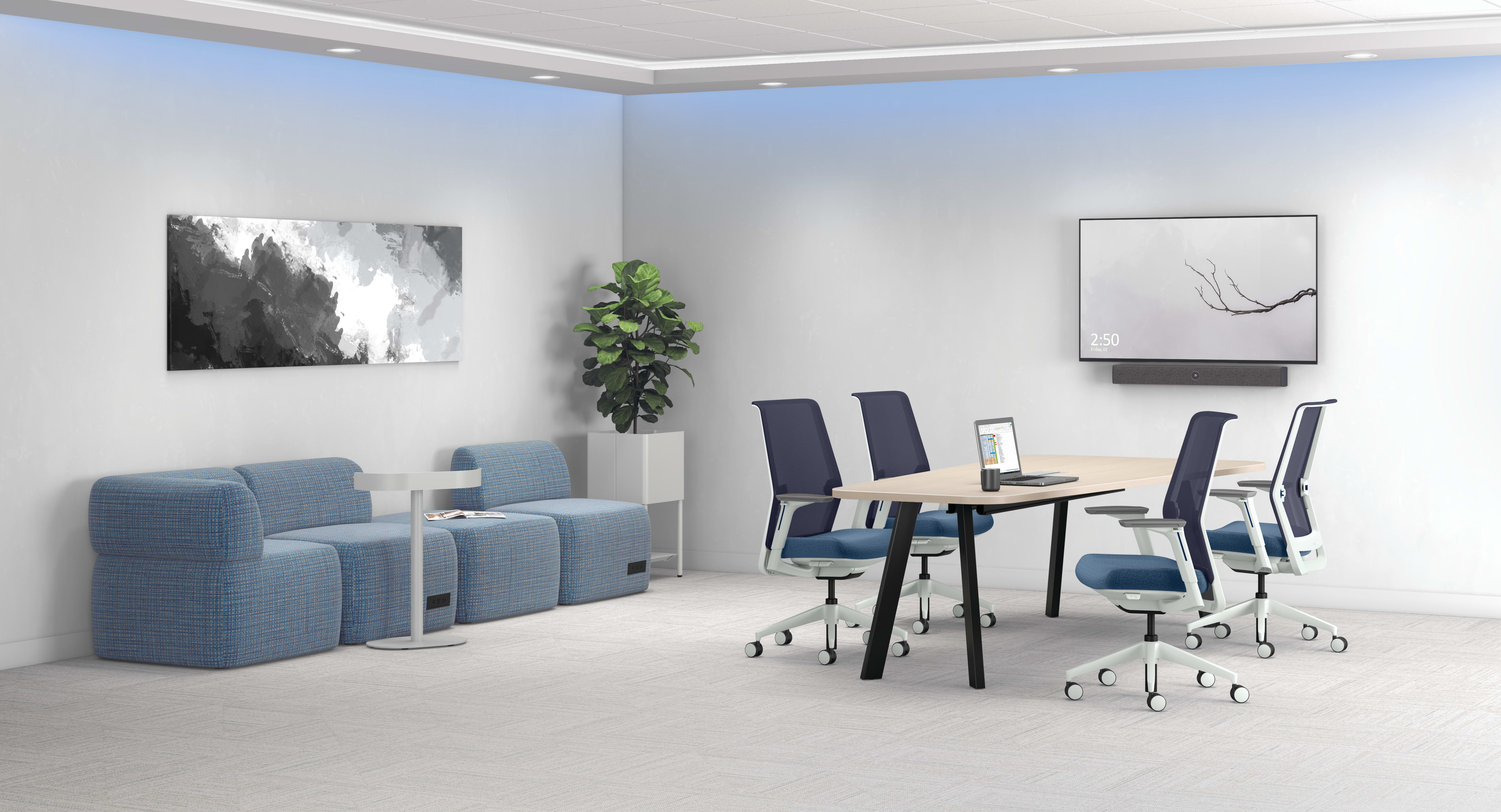 A modern and minimalist office space with gray and blue furniture, including chairs and a table, along with artwork and a potted plant decorating the walls.