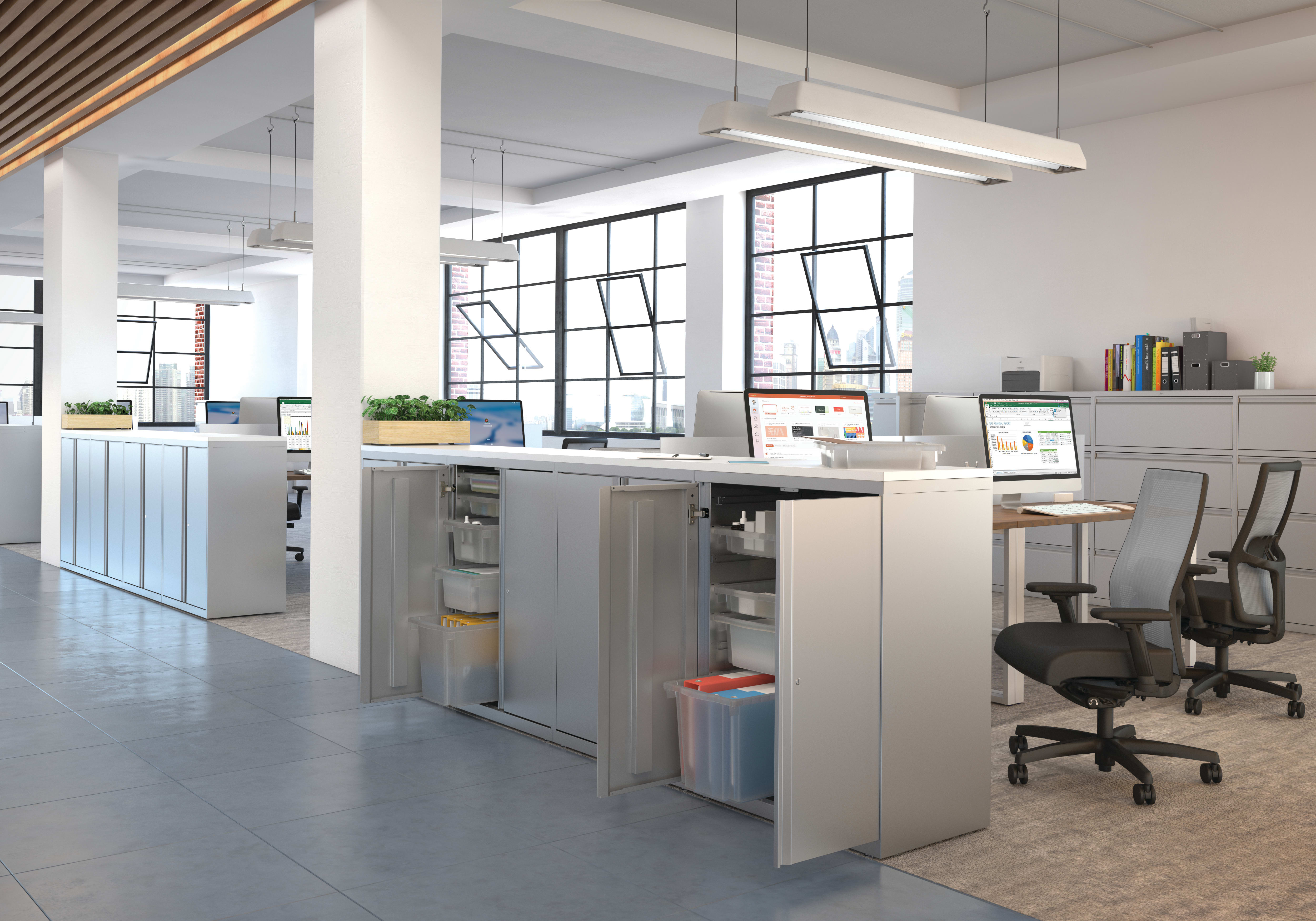 A modern and open-concept office space with a kitchen area, desks, and large windows providing ample natural light.