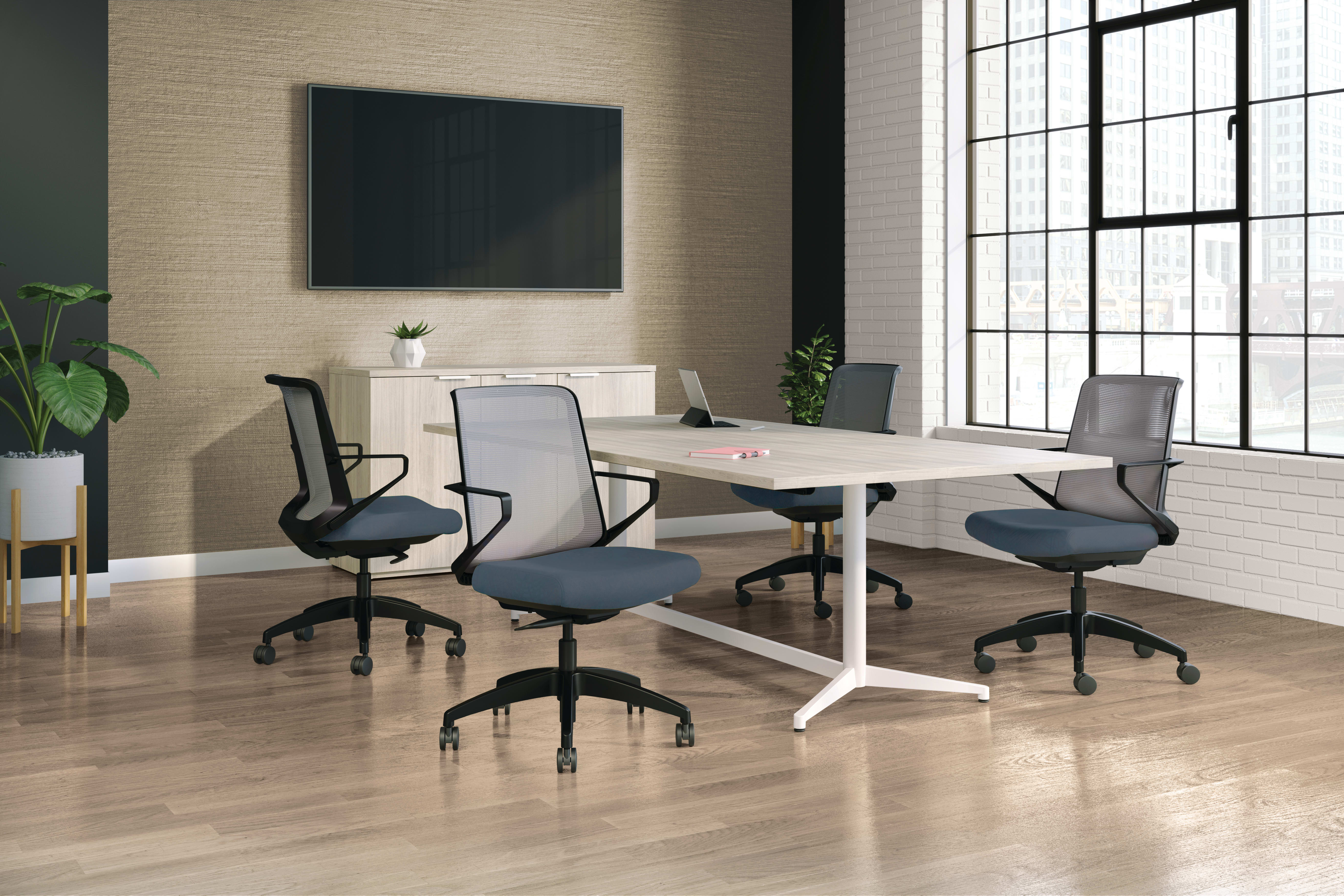 A modern, minimalist office space with a large conference table, comfortable office chairs, and a large wall-mounted display screen, set against a backdrop of large windows and a neutral-toned interior.