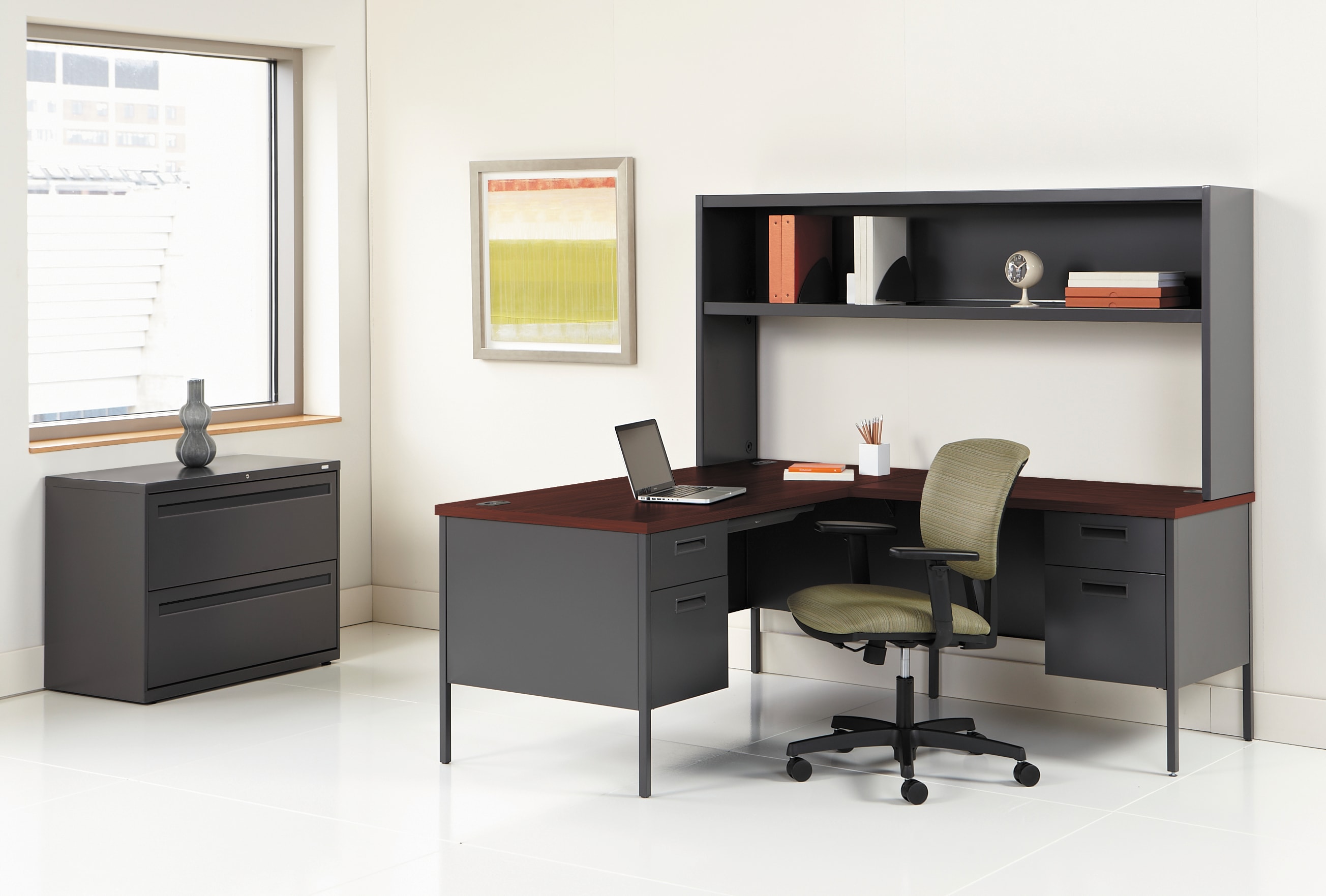 A modern and minimalist home office setup with a black desk, shelving unit, and a comfortable office chair.