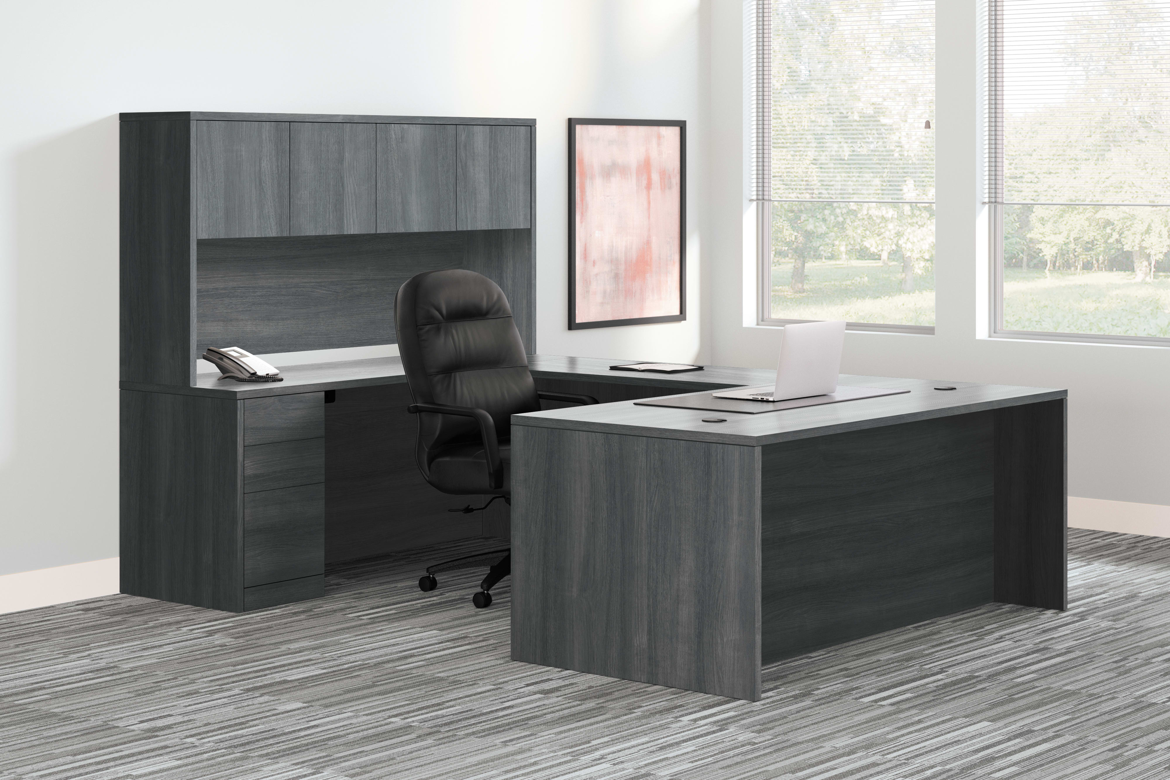 A modern and minimalist office workspace with a dark-colored desk, shelving unit, and a comfortable office chair situated in a bright, airy room with large windows.