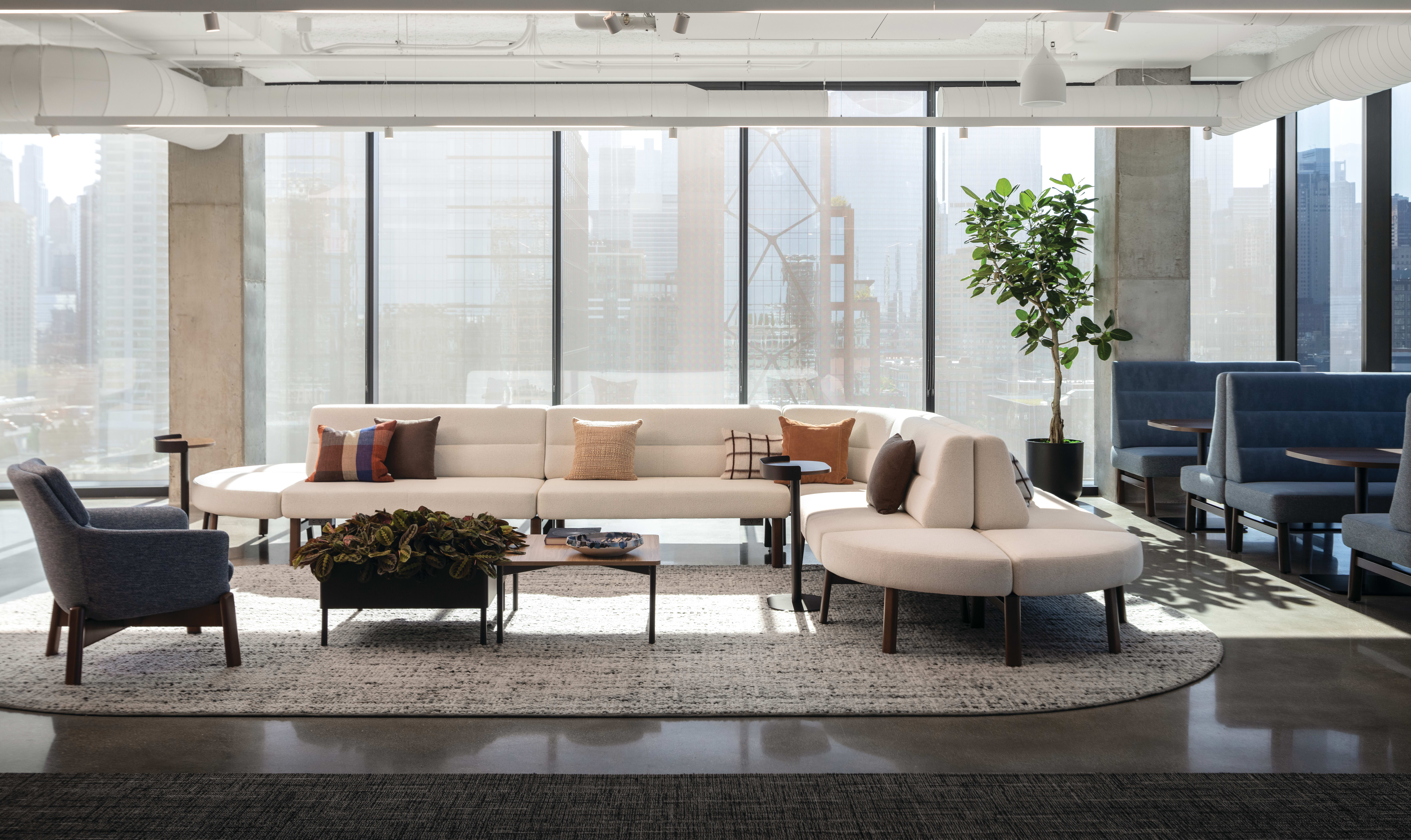 Rectangular coffee table with wood top and slim metal legs, paired with low round side tables for casual lounge use.