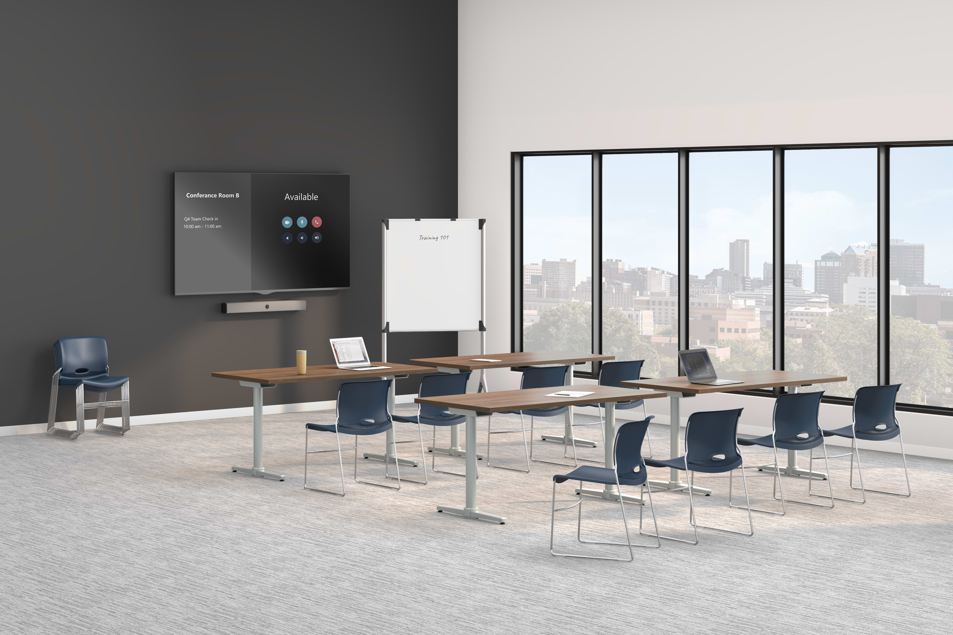A modern training room with long tables, blue chairs, a wall-mounted display screen, a whiteboard, and large windows overlooking a city skyline.