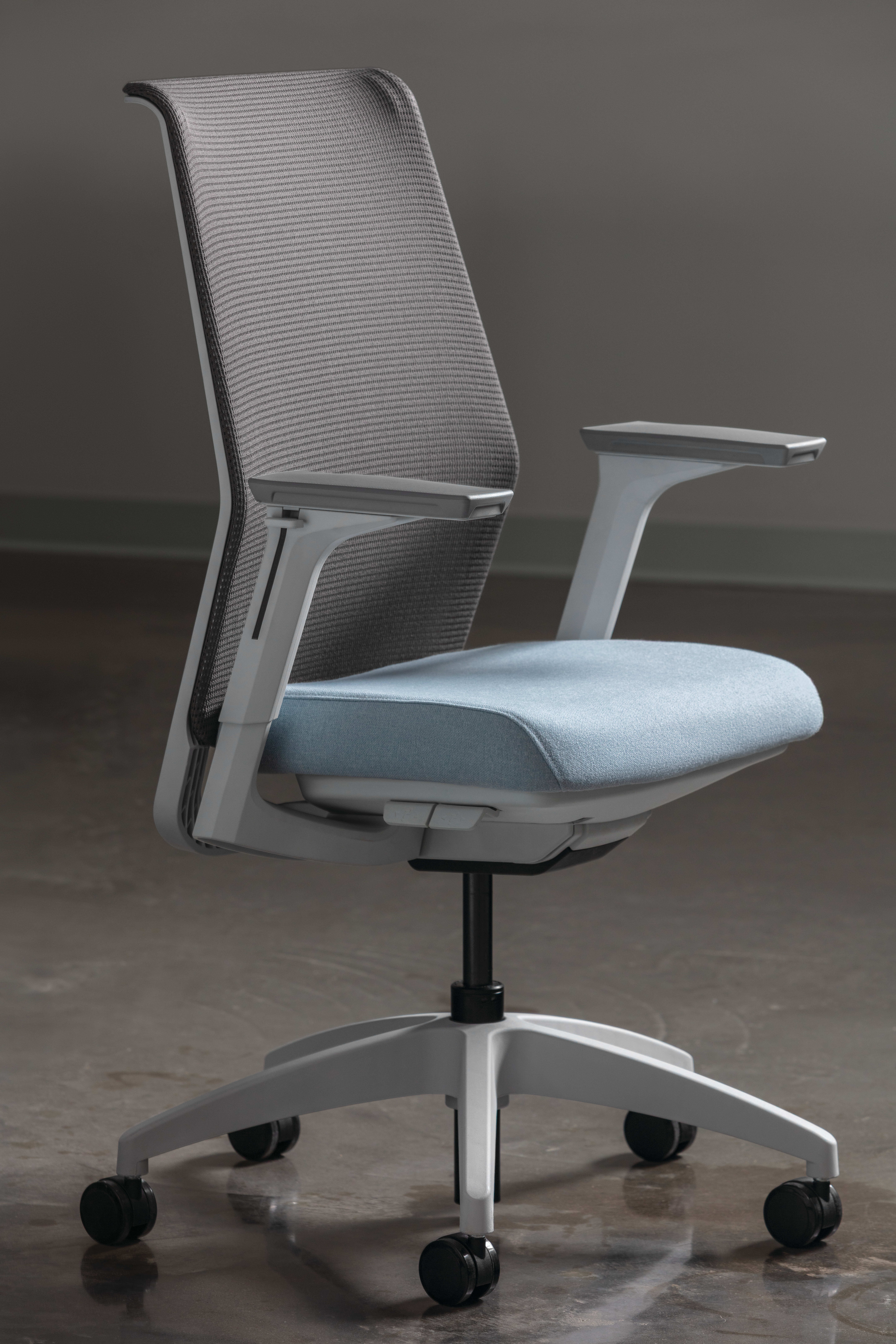 Side view of a modern task chair featuring a gray mesh backrest, light blue upholstered seat cushion, adjustable armrests, and a five-star caster base.