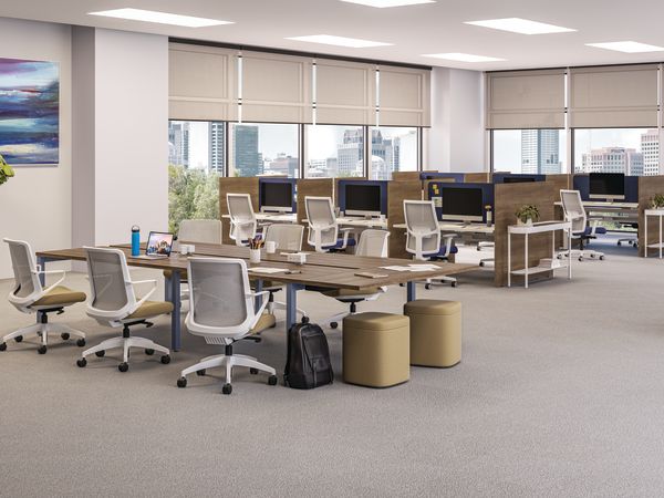 A modern and well-equipped office space with rows of desks, chairs, and computer equipment, set against a backdrop of large windows overlooking a cityscape.