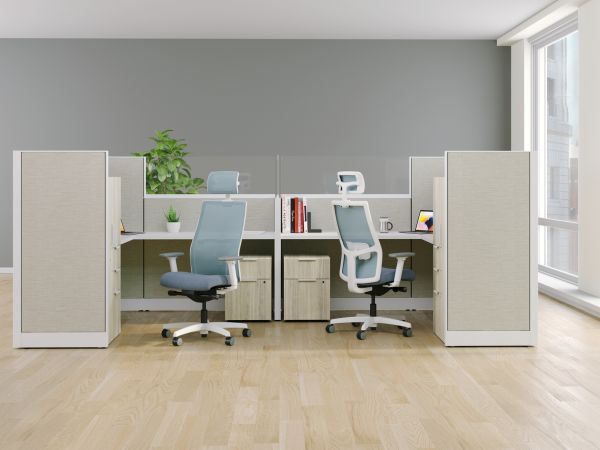 A modern and minimalist office space with white desks, ergonomic chairs, and shelving units, set against a gray wall and hardwood flooring, creating a clean and organized work environment.