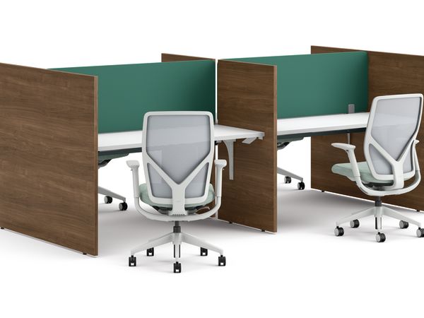 Two workstations with green fabric privacy panels, white desks, and ergonomic office chairs framed by wooden side panels.