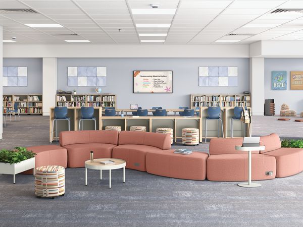 A large education collaborative space with pink SoCo soft seating, and blue SmartLink chairs