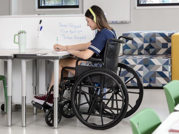 One student in a wheelchair at a Build desk next to the whiteboard back of a Class-ifi storage unit.