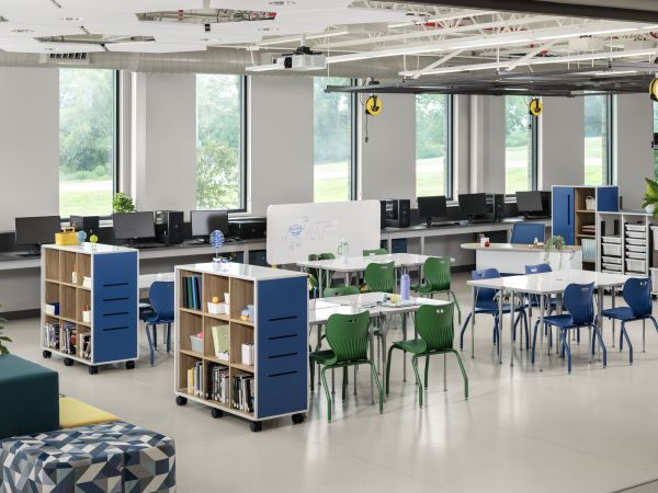 Makerspace classroom with blue and green chairs and storage solutions.