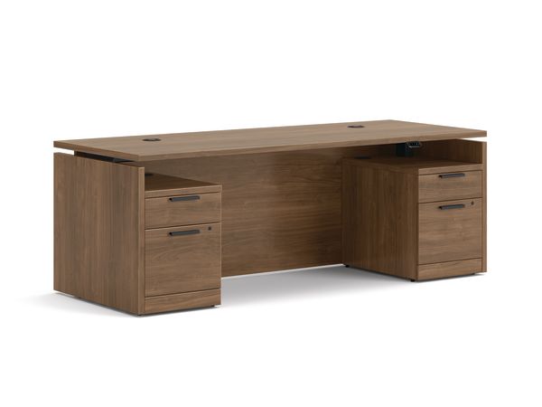 Double pedestal executive desk with woodgrain finish, integrated power access, and built-in file storage.