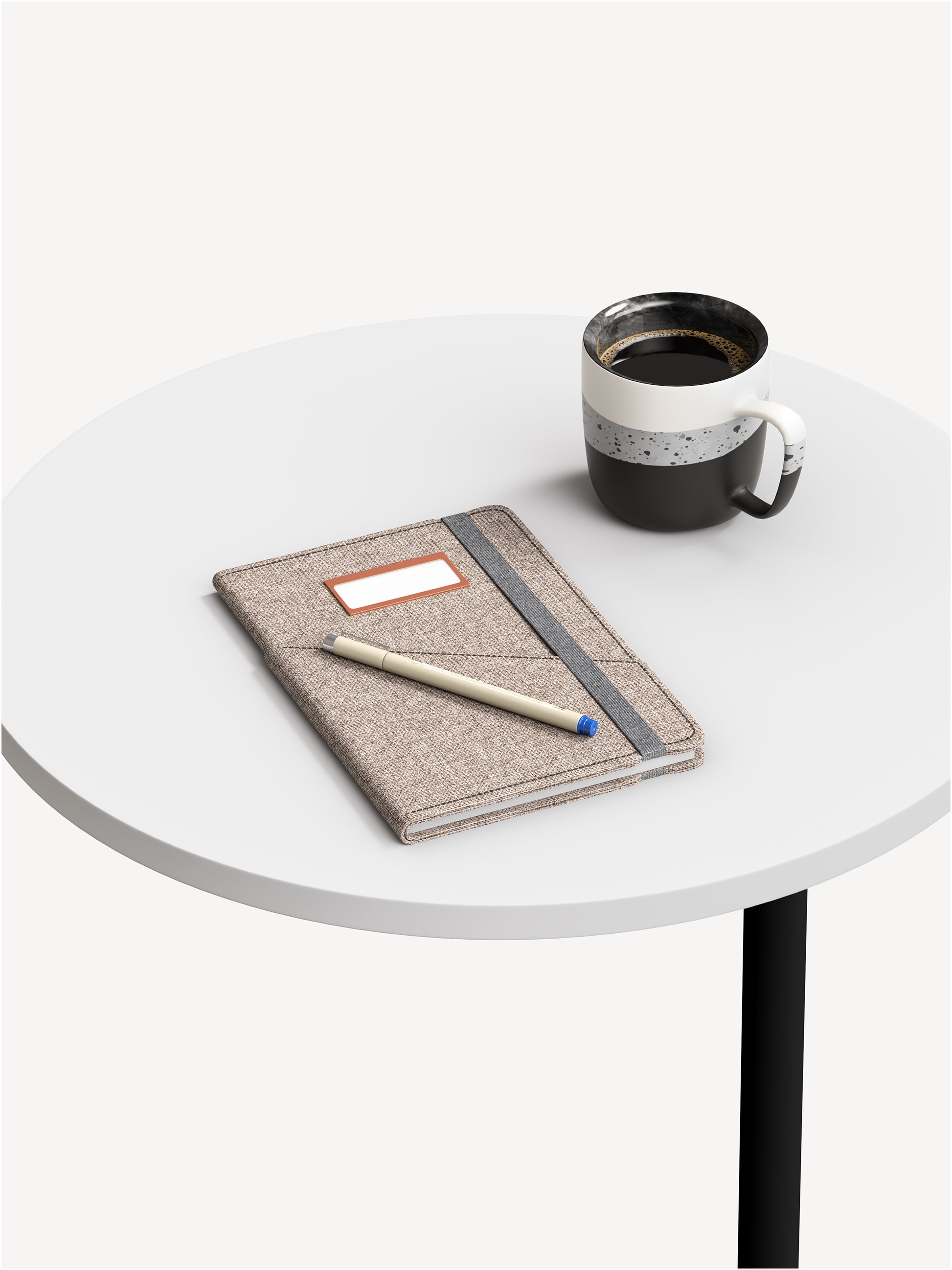 Detail view of a Rise occasional table with a black base and white, round table top with a coffee mug and notebook on top.