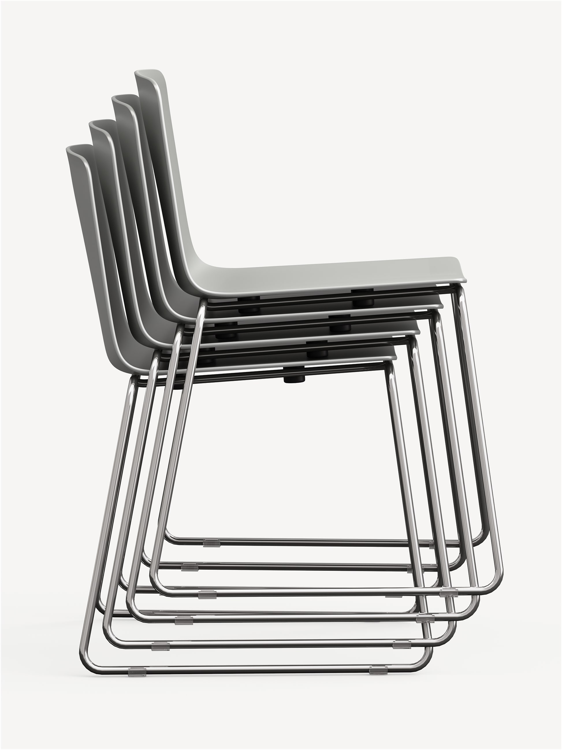 Four Vicinity stackable side chairs, stacked up, with chrome sled bases and light grey polymer shells.