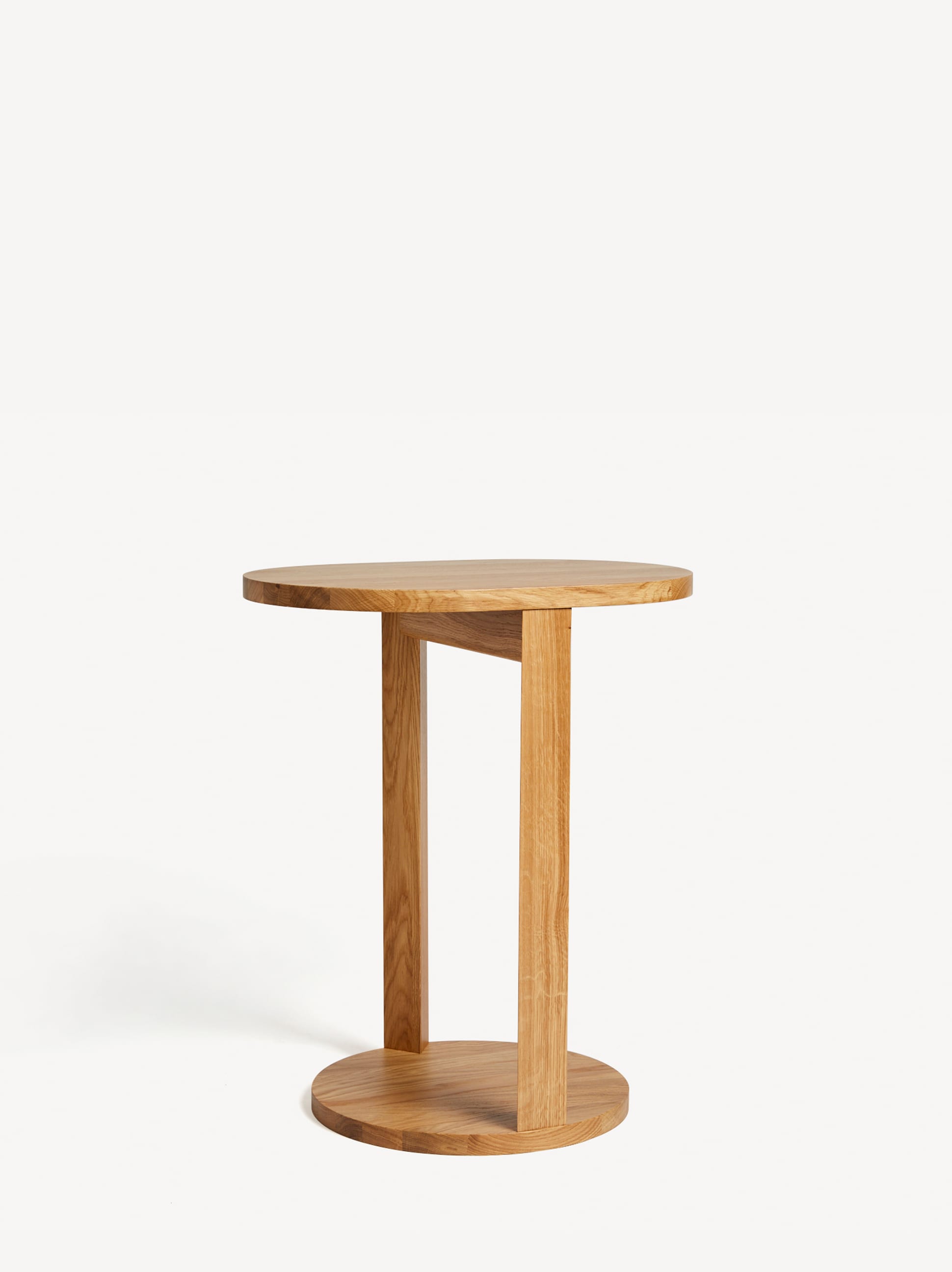 Unique Tuck side table in light oak with a round table top and split pedestal round base.