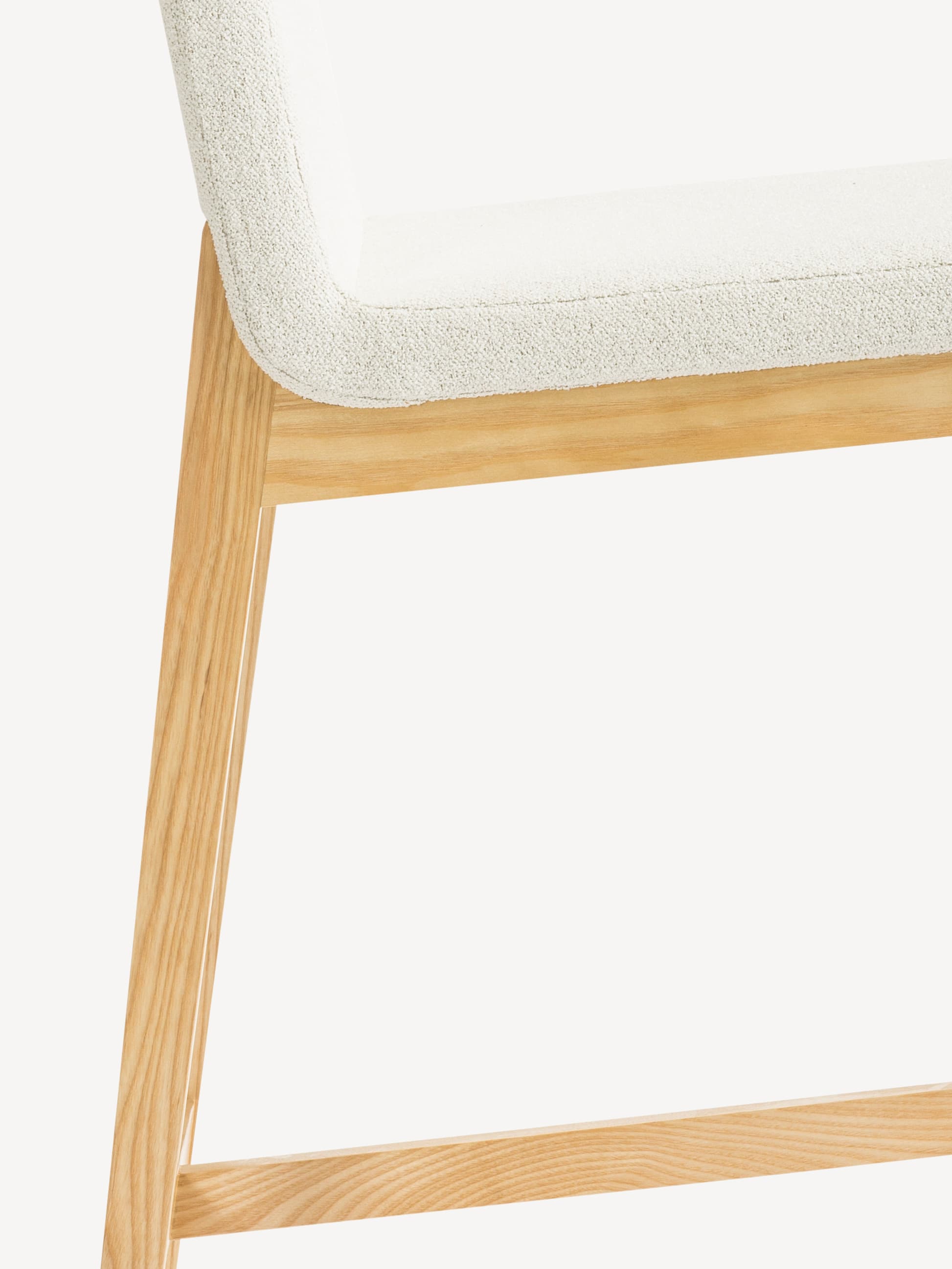 Detail view of the Gunlocke Tia stool with light wood frame and light beige upholstery.