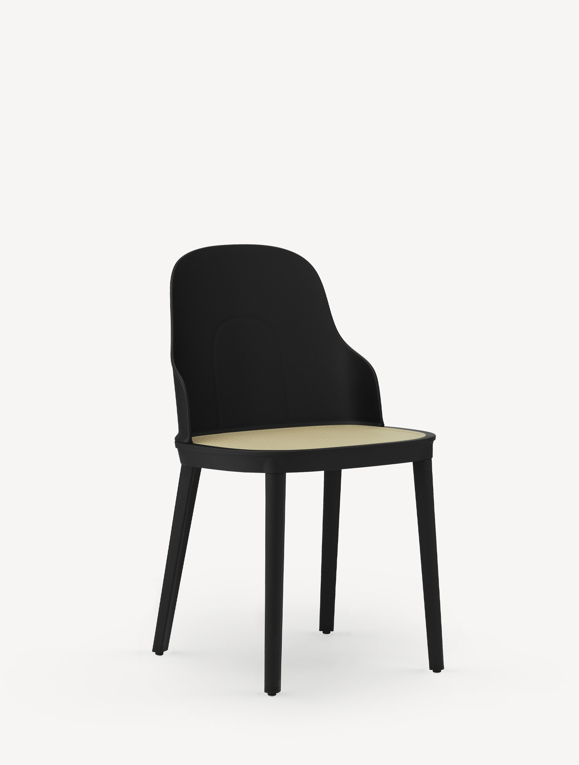 Three-quarter view of the Normann Copenhagen Allez Chair with molded wicker seat and black base and shell.