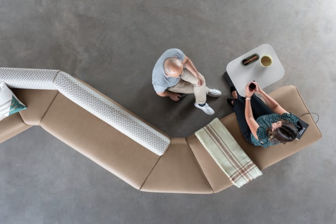 Aerial view of modular lounge furniture with two people seated, having a conversation.