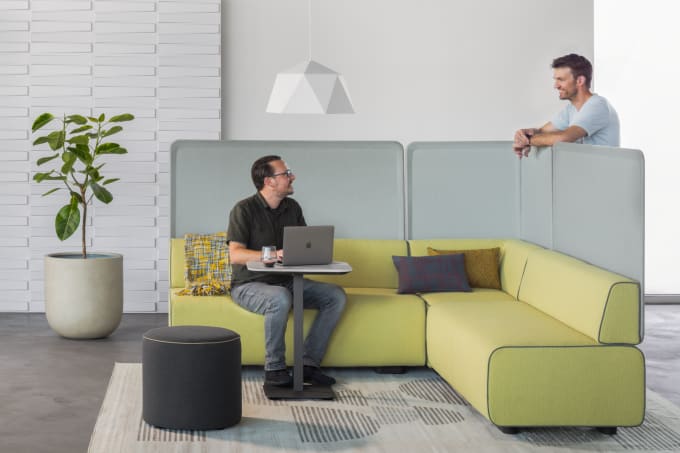 Modern modular lounge setting in green and grey two people collaborating.