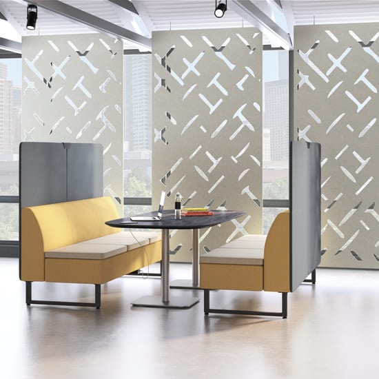 A modern and minimalist office space with yellow and gray furniture, geometric patterns on the walls, and large windows providing natural light.