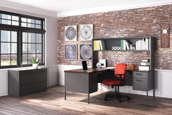 A modern and stylish home office with a brick wall, shelves, a desk, and a red office chair.