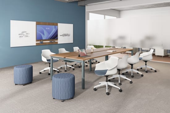 Modern conference room with long meeting table, white task chairs, wall-mounted presentation screen, blue accent wall, and glass partition.