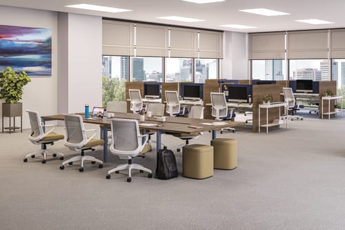 A modern and well-equipped office space with rows of desks, chairs, and computer equipment, set against a backdrop of large windows overlooking a cityscape.