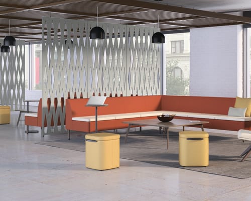 A modern and stylish office space with an orange sectional sofa, wooden accents, and a unique lighting fixture creating a visually interesting and inviting atmosphere.