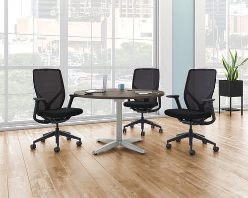 A Preside round conference table with three Flexion task chairs.