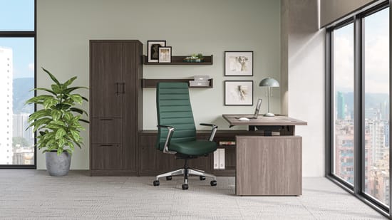 Modern private office with wood desk and storage cabinets, green task chair, framed wall art, and floor-to-ceiling windows with city views.